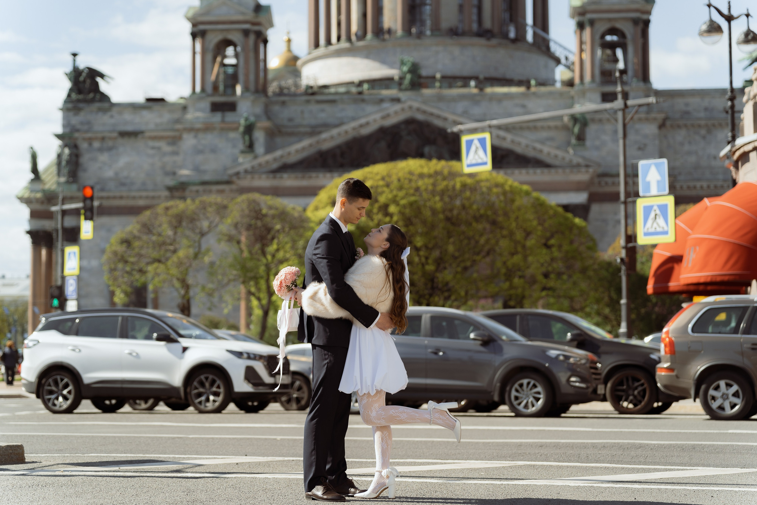 Объятия жениха и невесты на фоне городской архитектуры, романтичный момент