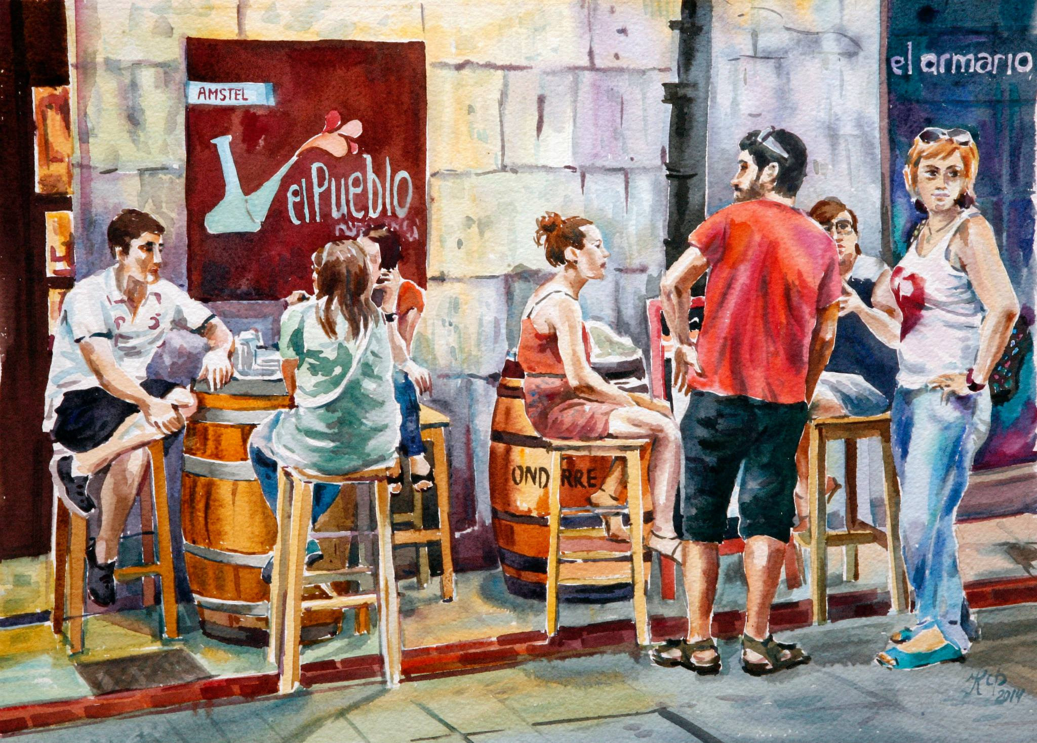 A group of young people sitting at barrel tables in the bar El Pueblo.