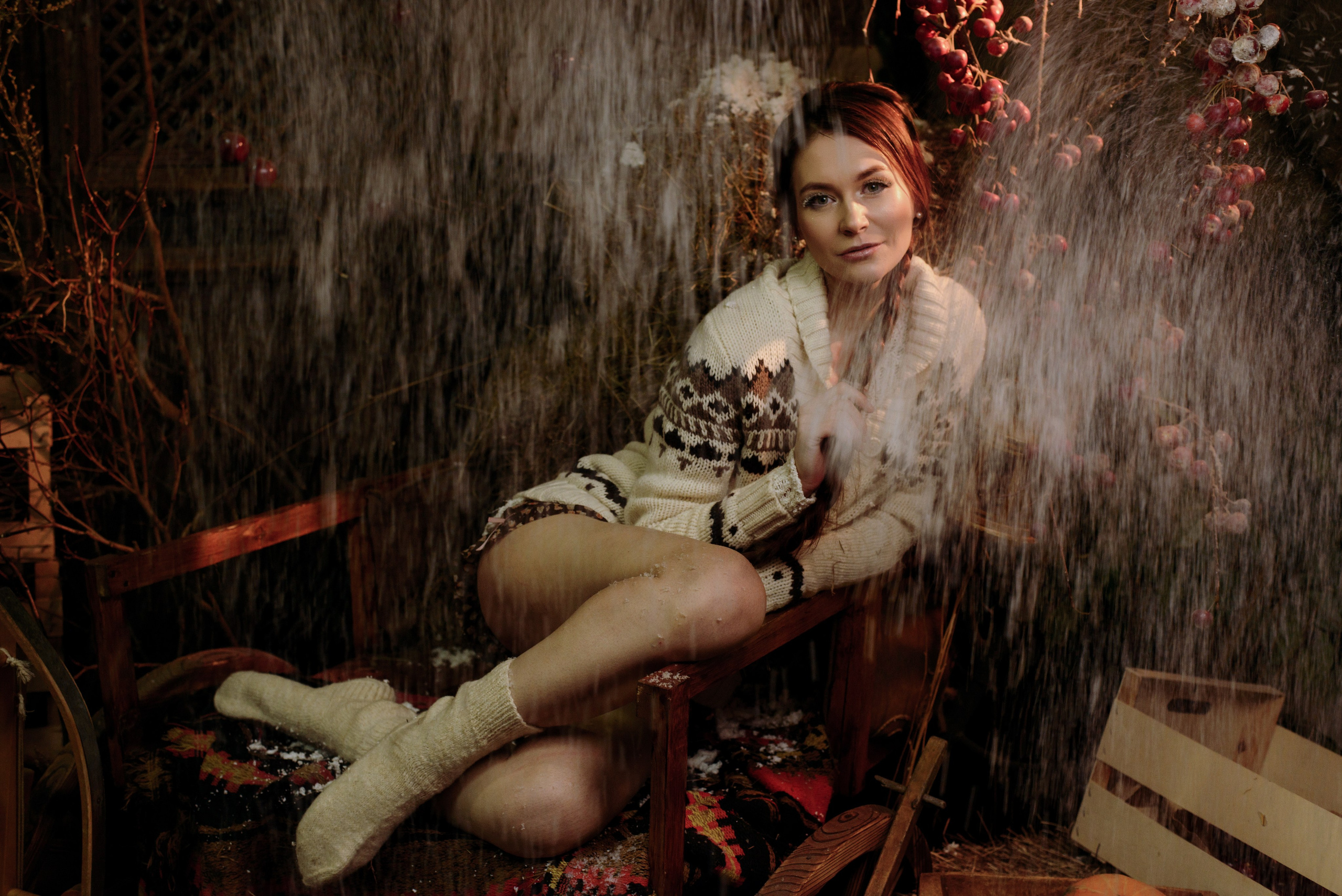 Фотосессия в зимнем стиле в студии девушки в вязанном свитере и носках с длинной косой