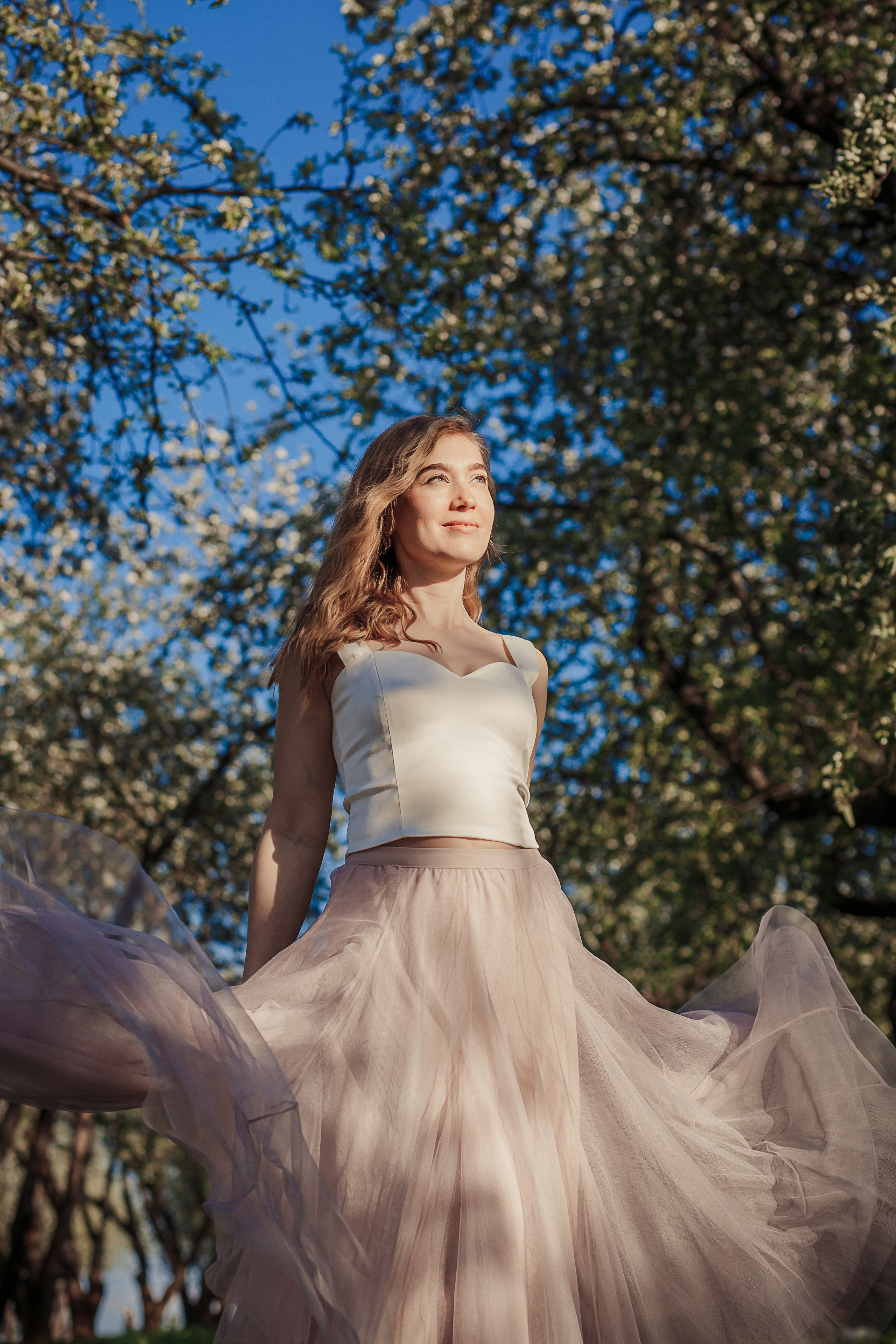 rina_sphoto, фотограф Катерина Сысуева, Рина Сысуева, женский фотограф Москва, профессиональный фотограф москва, девушка в белой блузке и розовой юбке в яблоневом саду, развевающаяся юбка