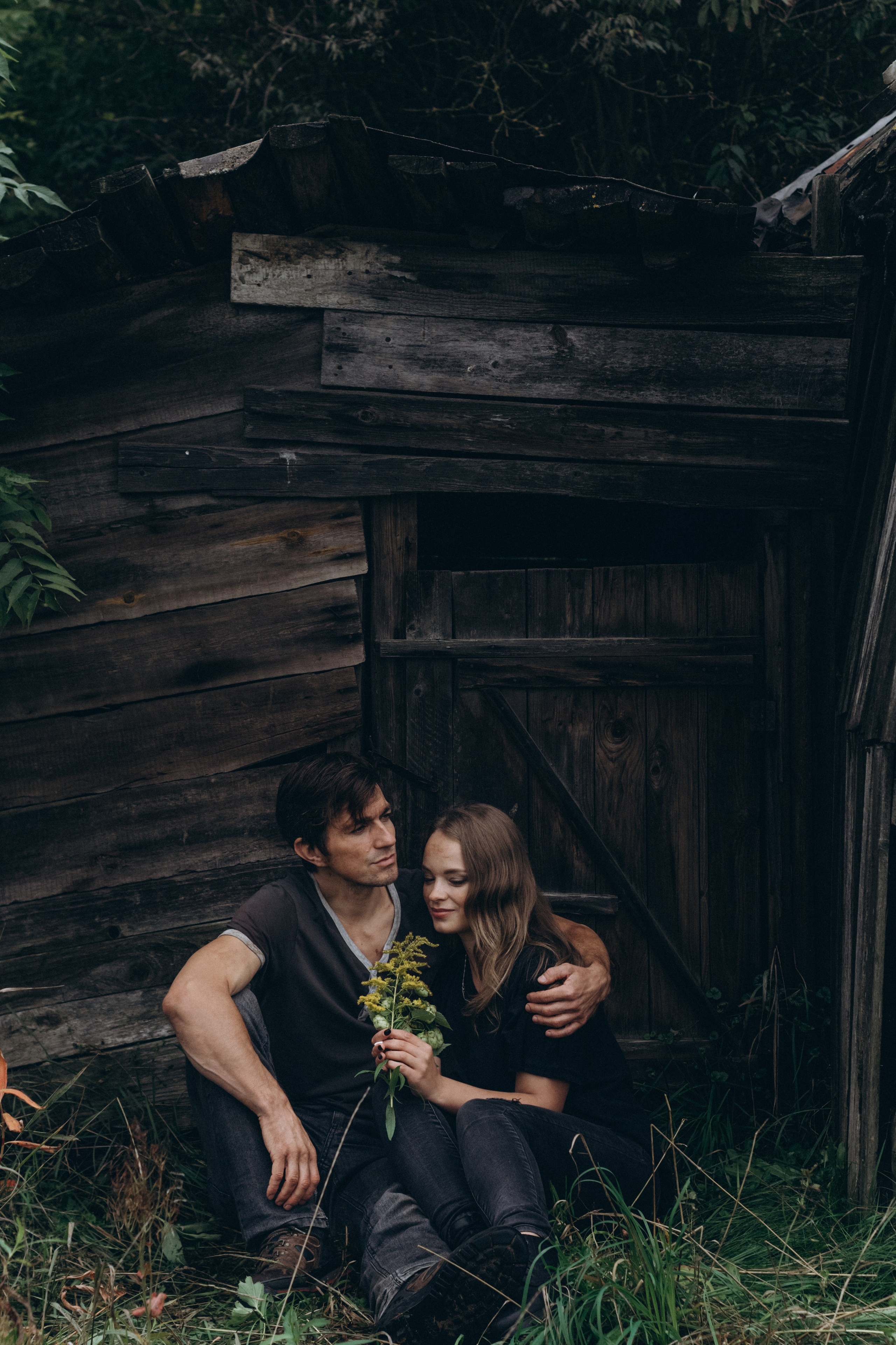 Парень обнимает девушку возле лесного домика