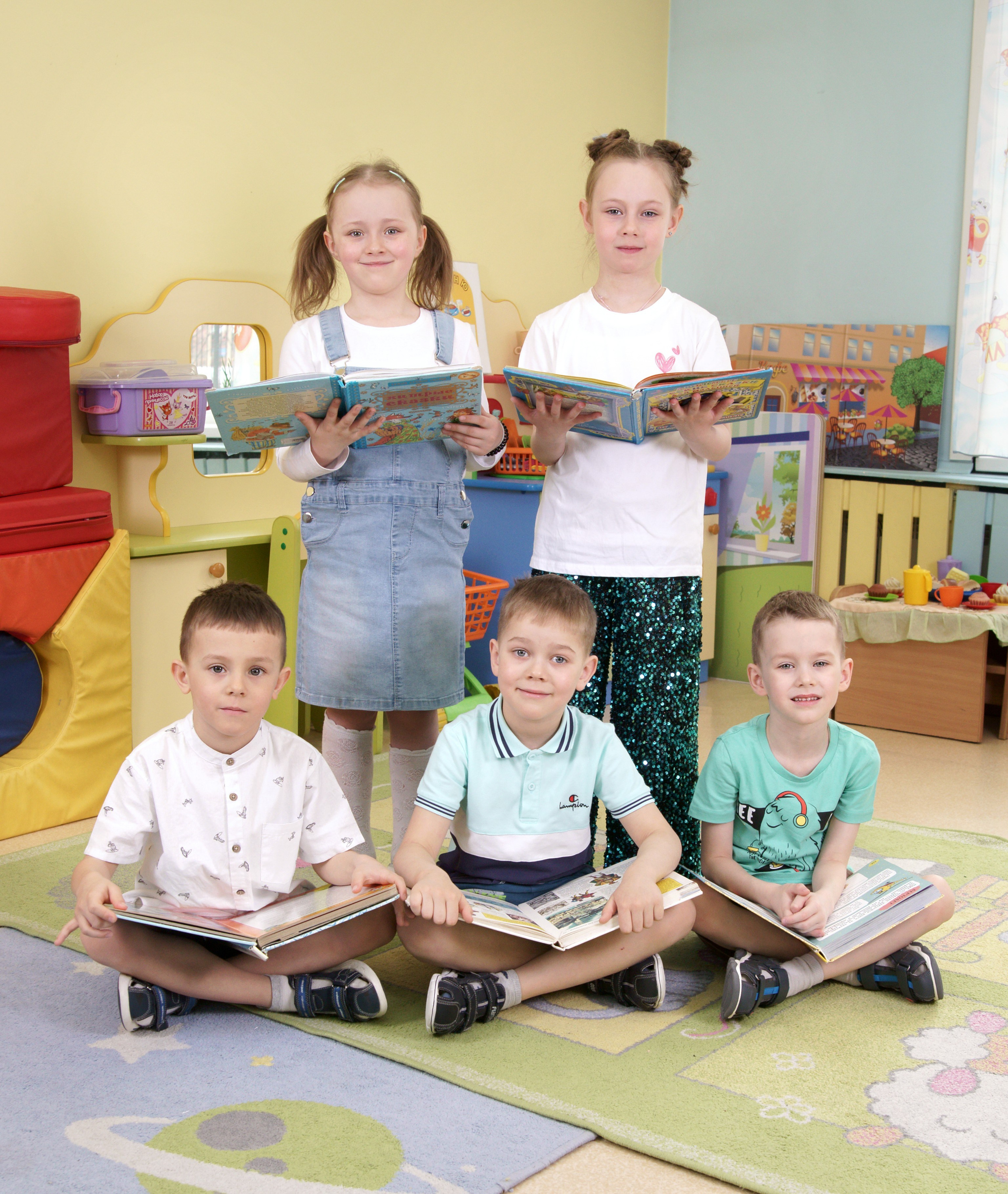 Фотосессия выпускников детского сада в группе - сидя с книгами
