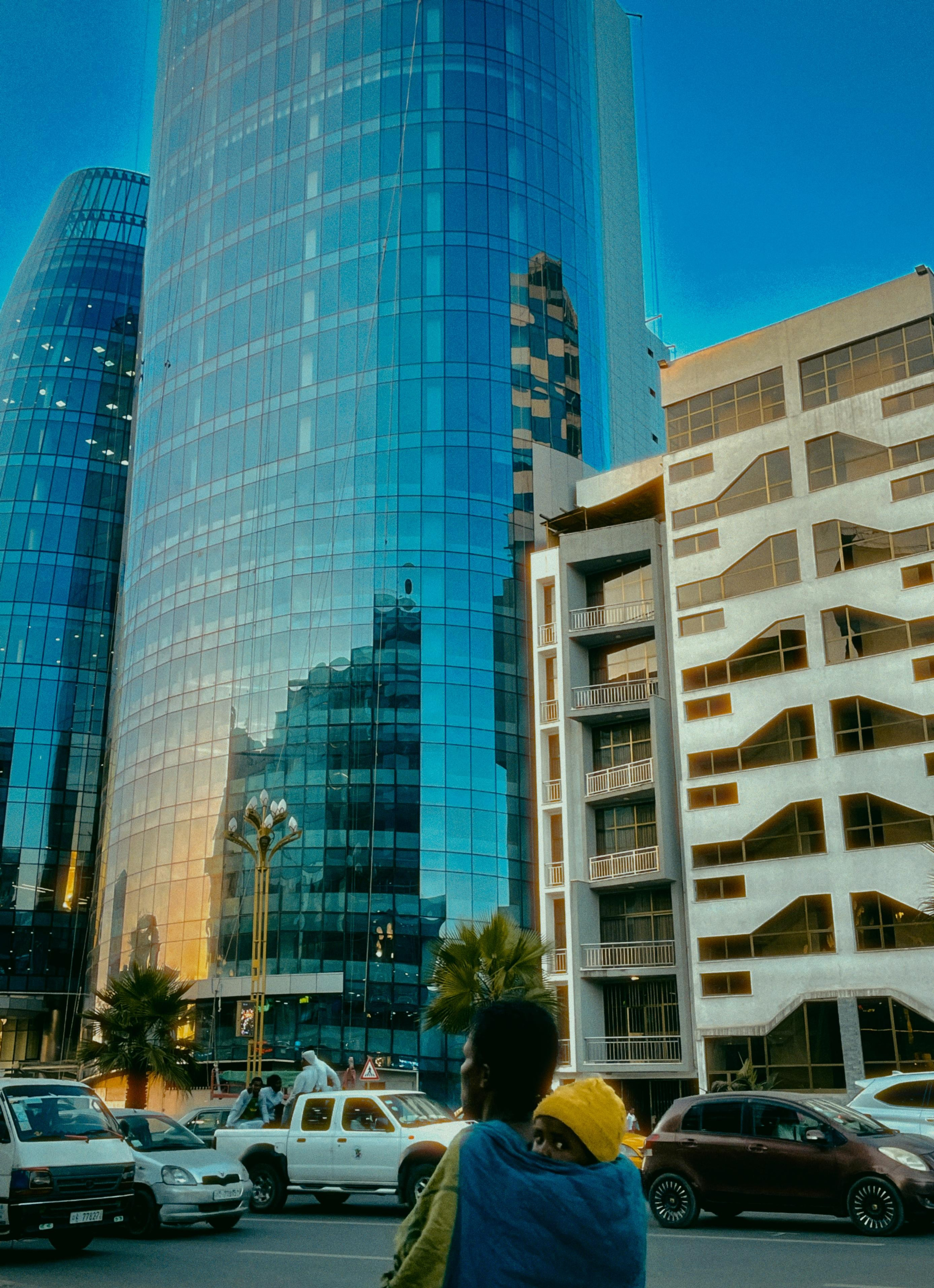 Небоскребы на главной улице столицы Эфиопии Аддис Абеба и мама несет ребенка в платке