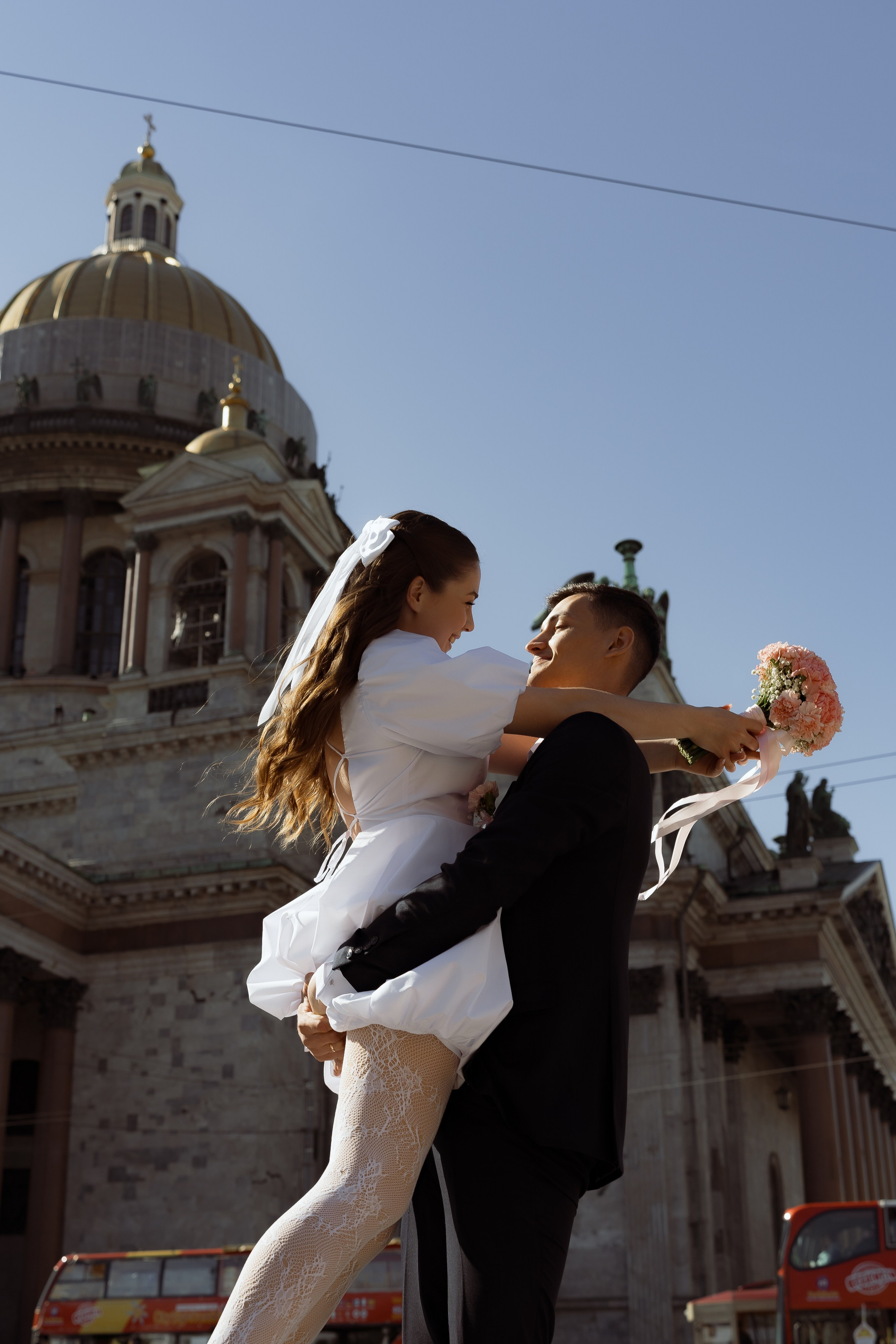 Жених кружит невесту на фоне Исаакиевского собора, радость свадебной прогулки