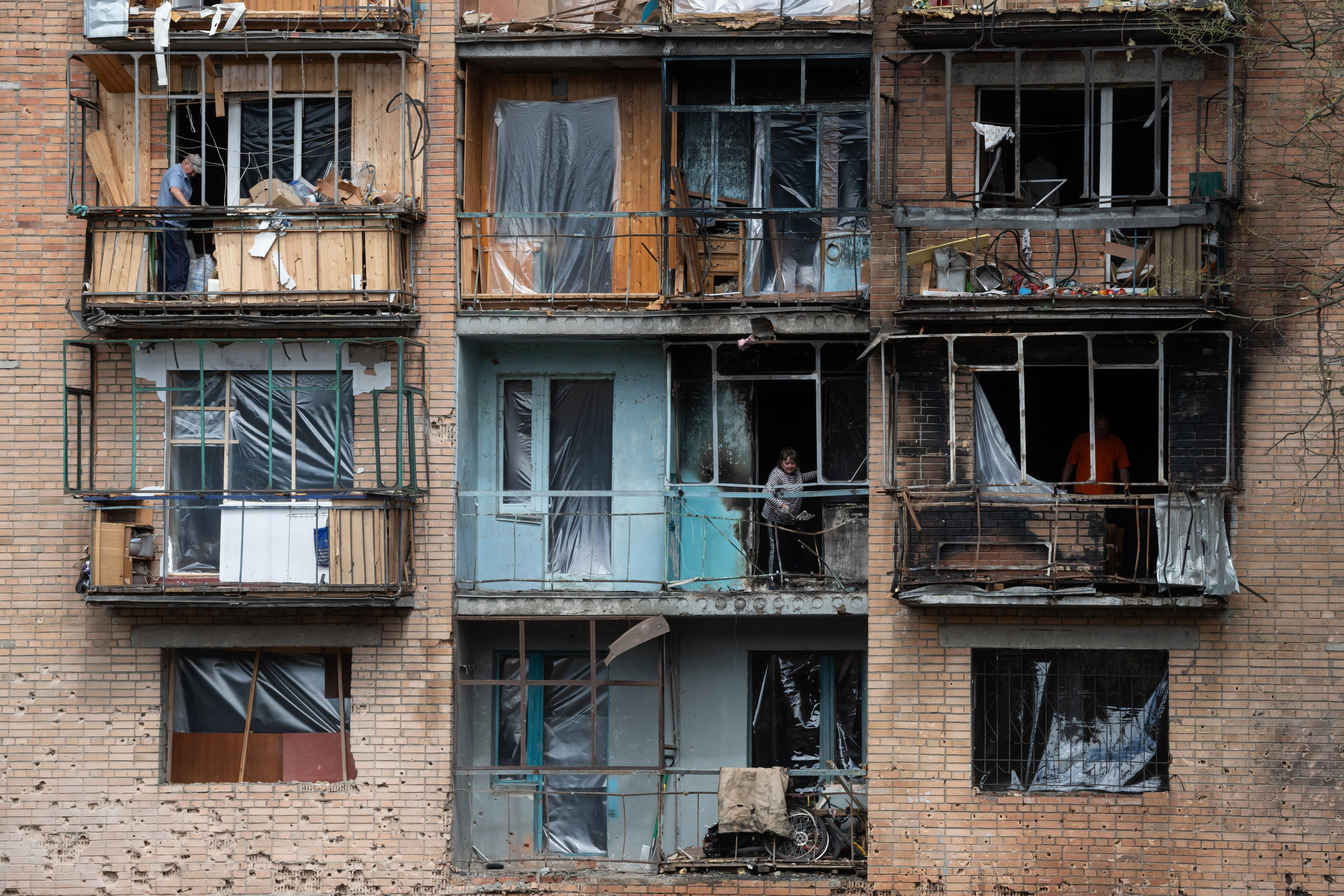Residents clean up apartments in a residential building damaged by shelling from the Ukrainian side in Kursk, Russia, Tuesday, August 13, 2024.