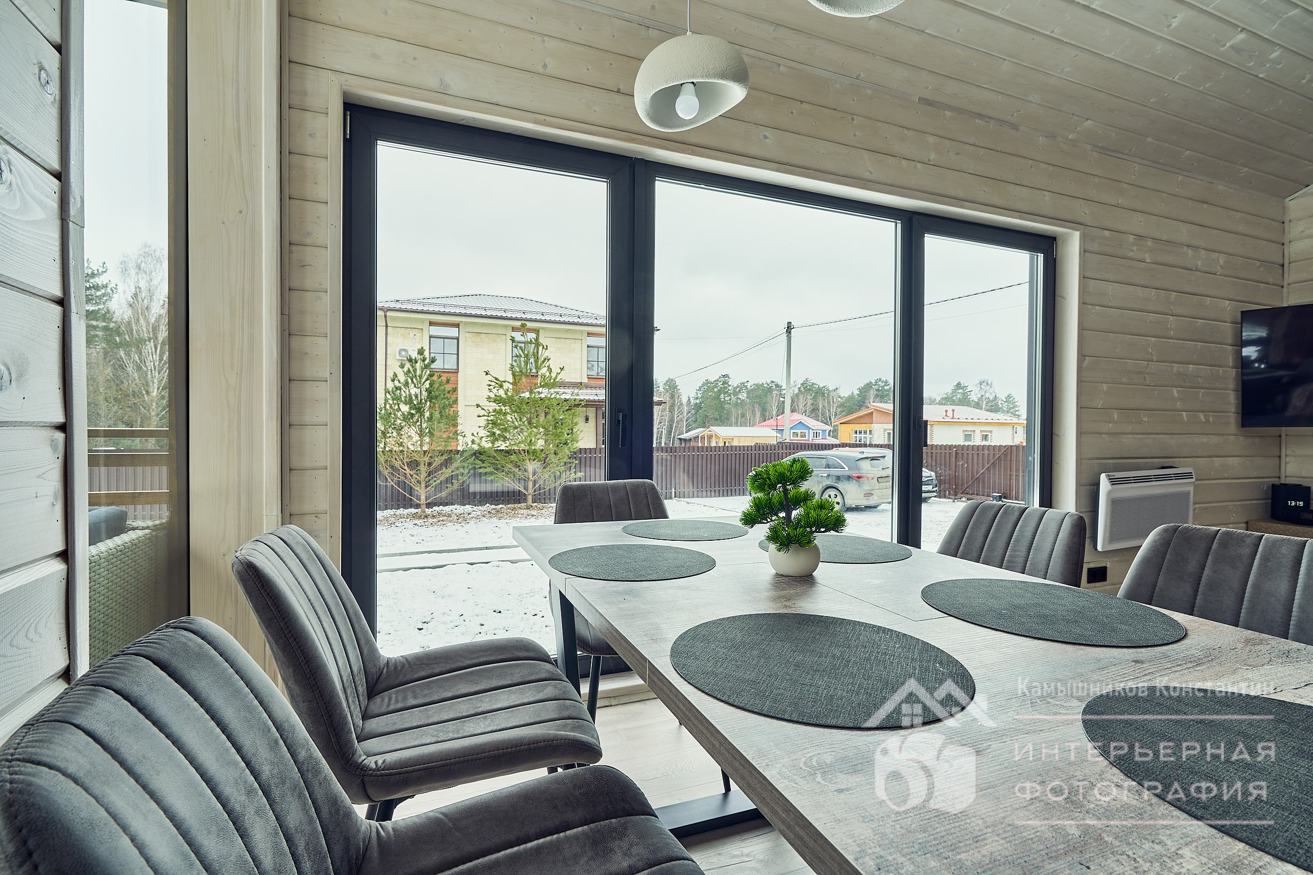 Интерьерная съемка с обеденным столом и панорамным окном в загородном доме в Подмосковье