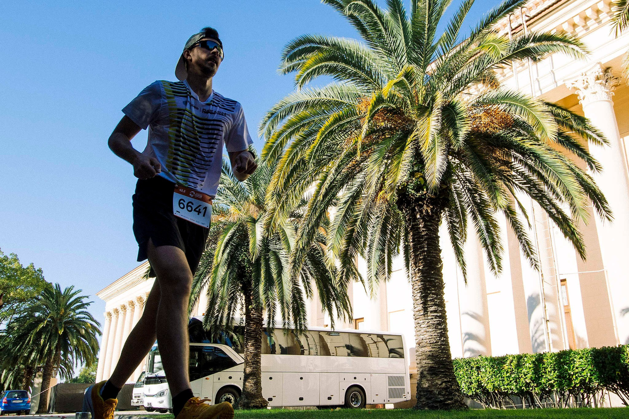 Атлет пробегает мимо Зимнего театра