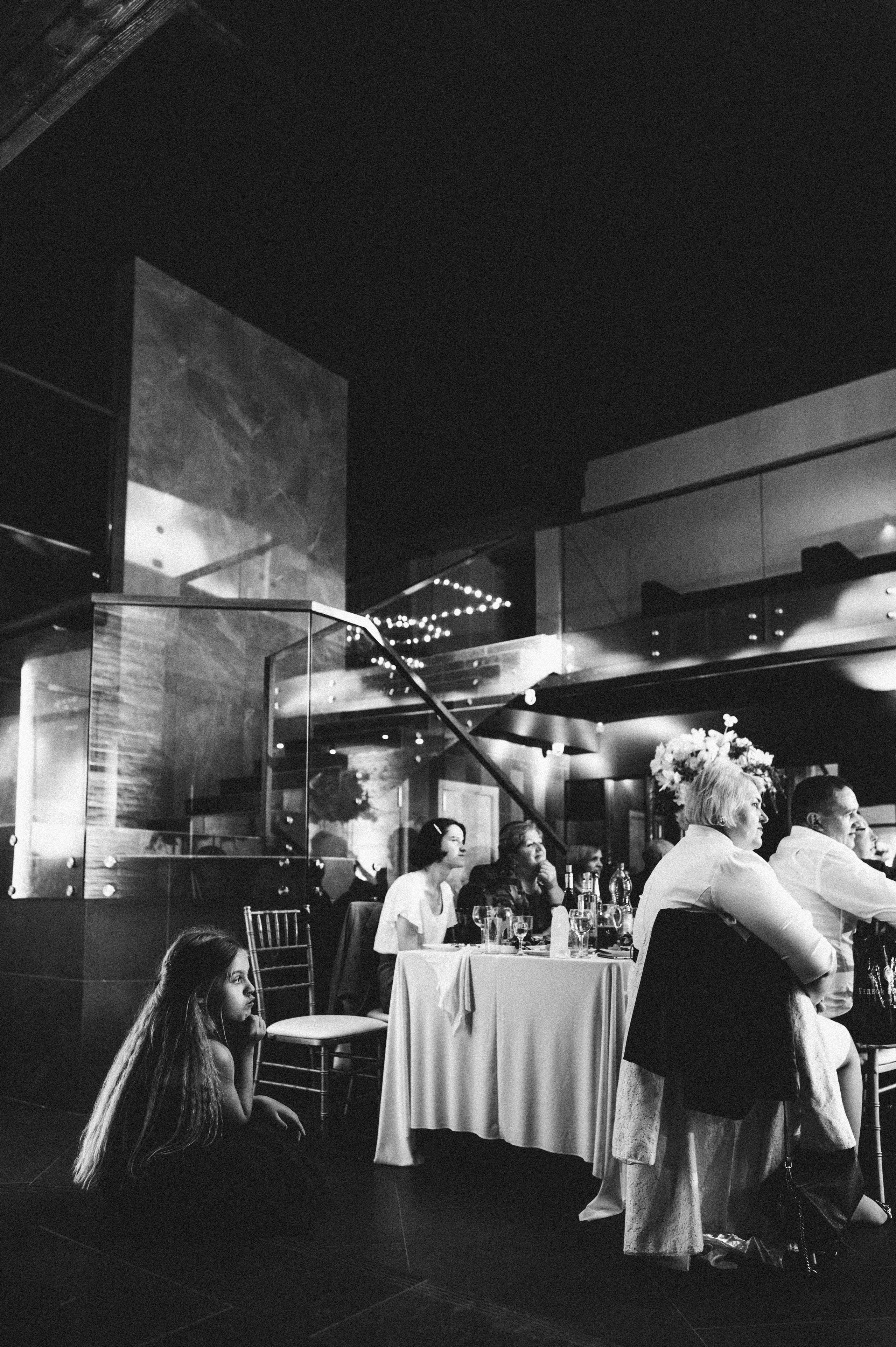 Черно-белая фотография гостей за столом со свадьбы
