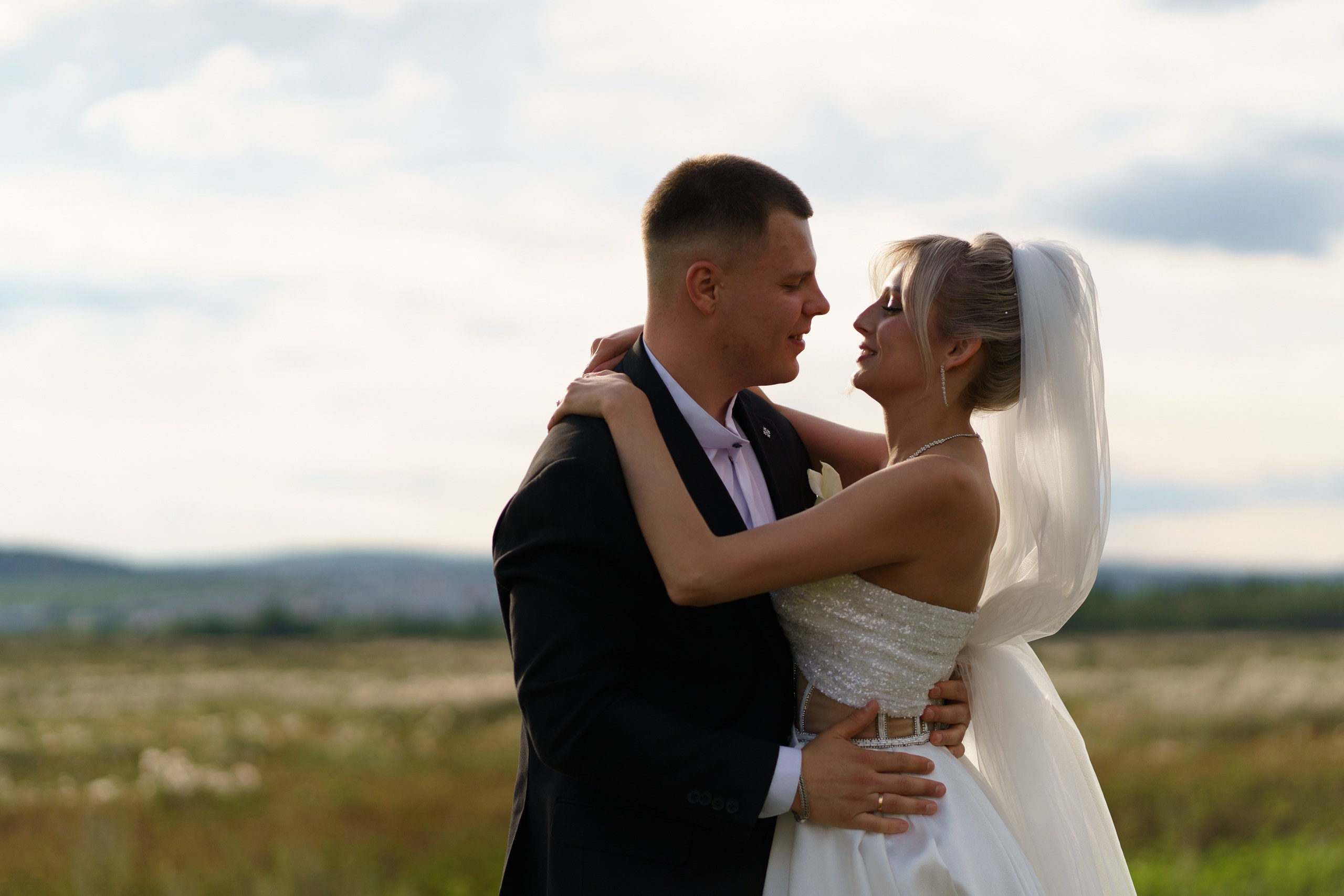 Симфония чувств: взгляд жениха полон нежности, а улыбка невесты — как утренний свет. Они стоят на пороге новой жизни, окружённые теплом природы |