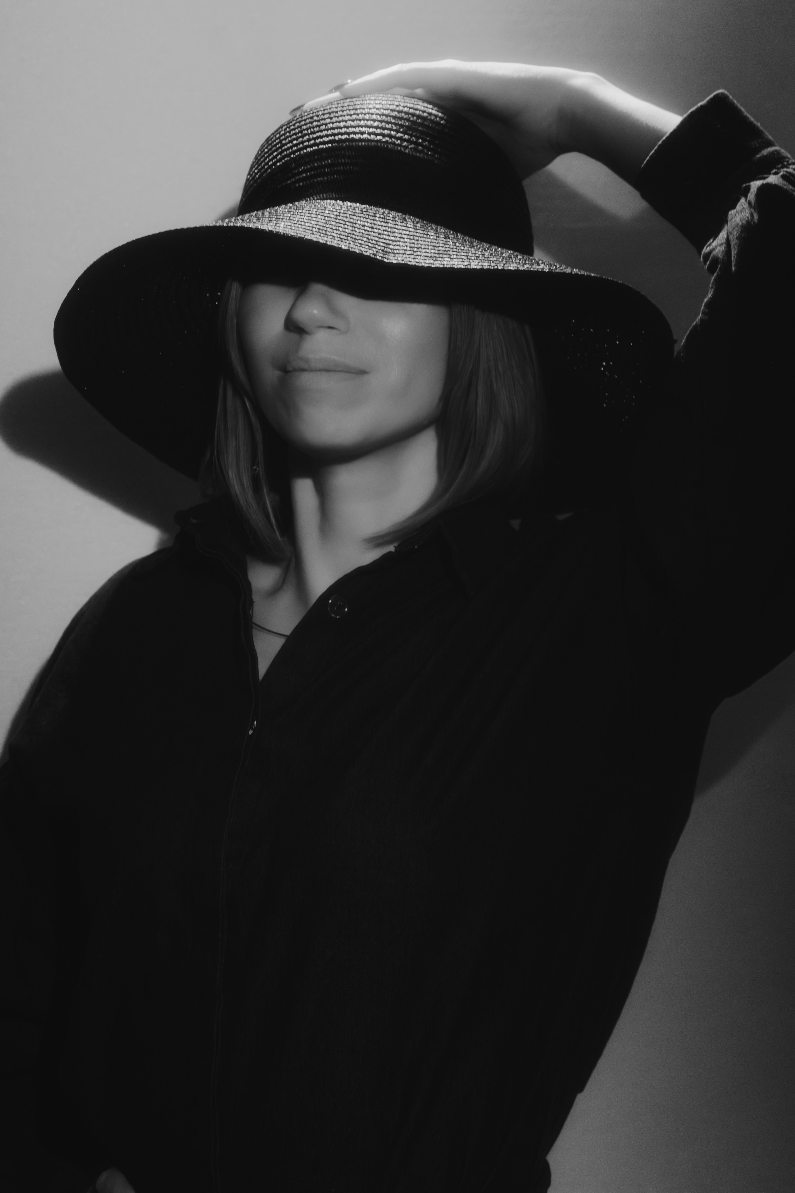 Таролог в созерцательной позе, руки у лица. Мягкий свет создаёт нежные блики на скулах.