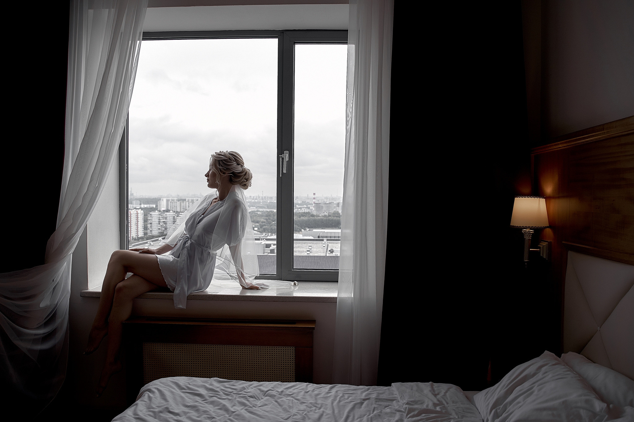Утро у окна. невеста сидит на подоконнике и смотрит в окно Свадебная фотосъемка в  отеле Милан. Свадебный фотограф в Москве  Сергей Гаварос.