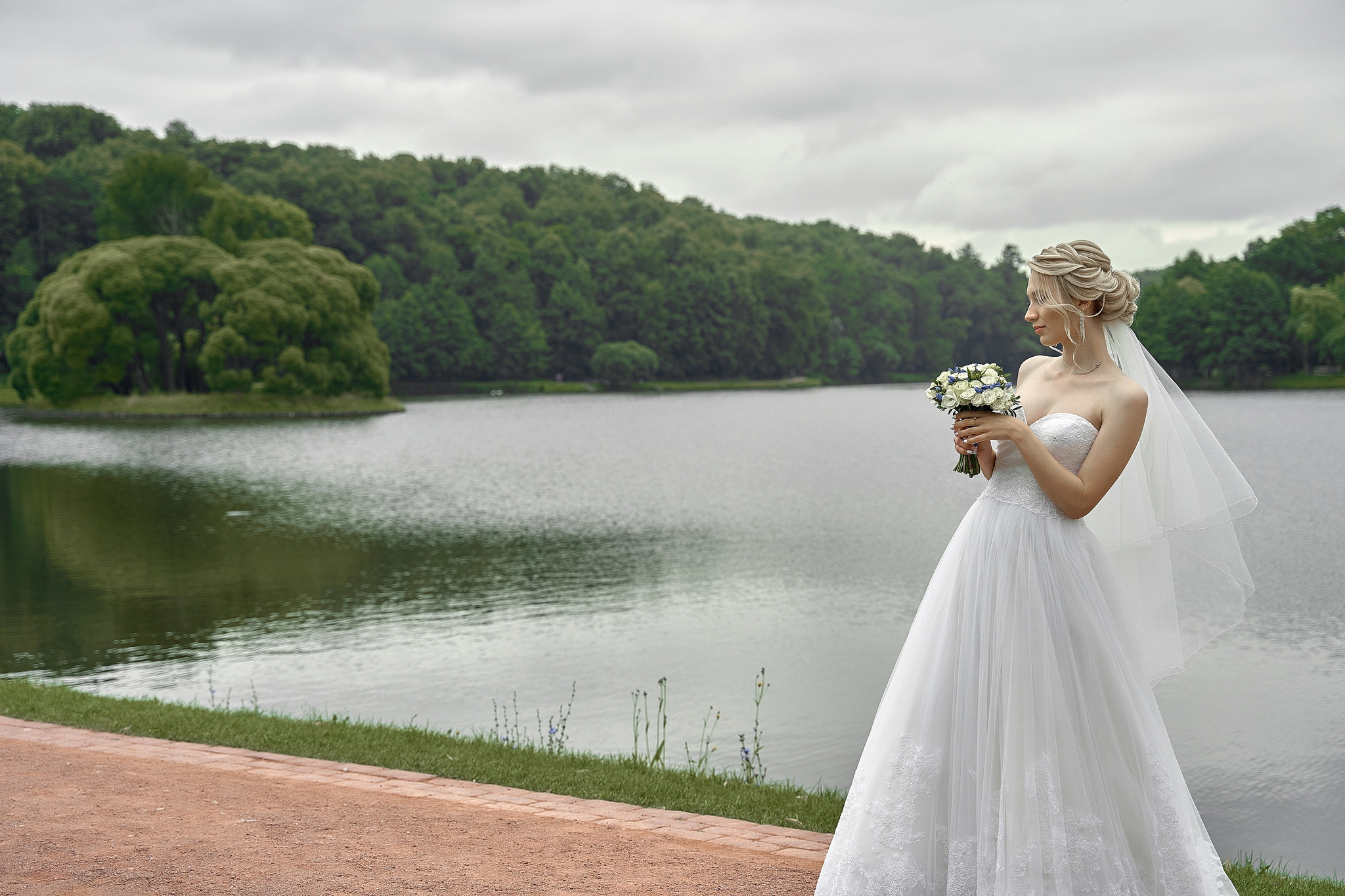 Невеста с букетом на фоне озера и леса  Свадебная фотосъемка в  Царицино. Свадебный фотограф в Москве  Сергей Гаварос.