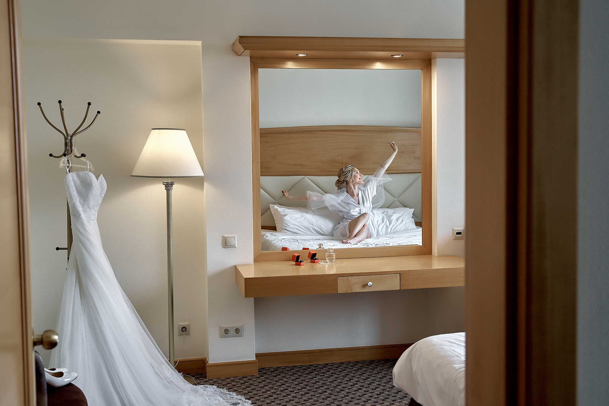 Невеста смотрит на свадебное платье через зеркало. Свадебная фотосъемка в  отеле Милан. Свадебный фотограф в Москве  Сергей Гаварос.