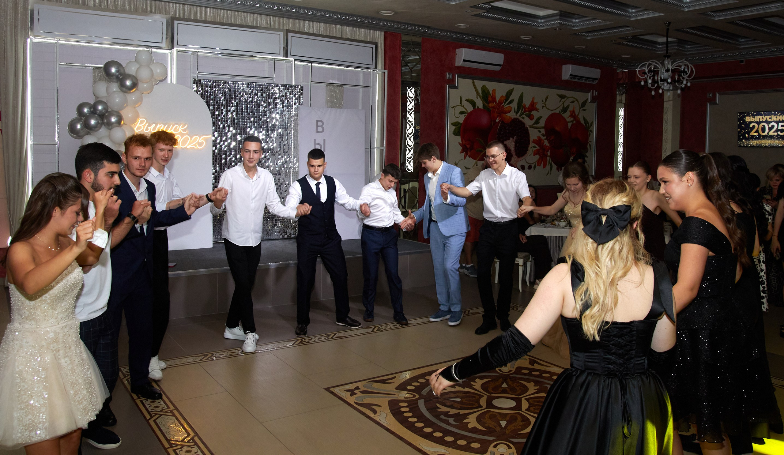 Атмосфера праздника в банкетном зале: танцы и гости выпускного