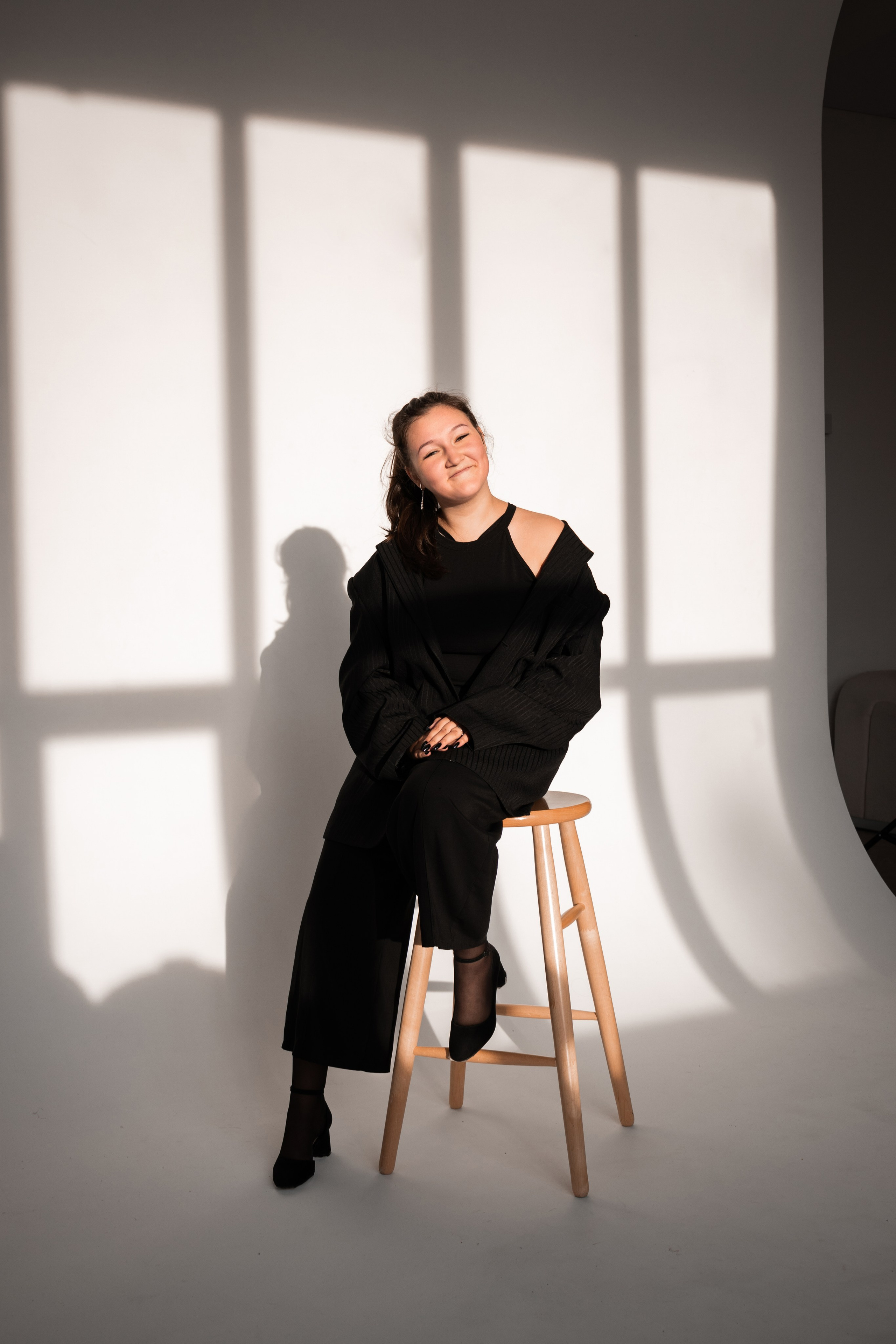 Студийная фотосессия девушки в чёрном образе при лучах солнца в городе Томск