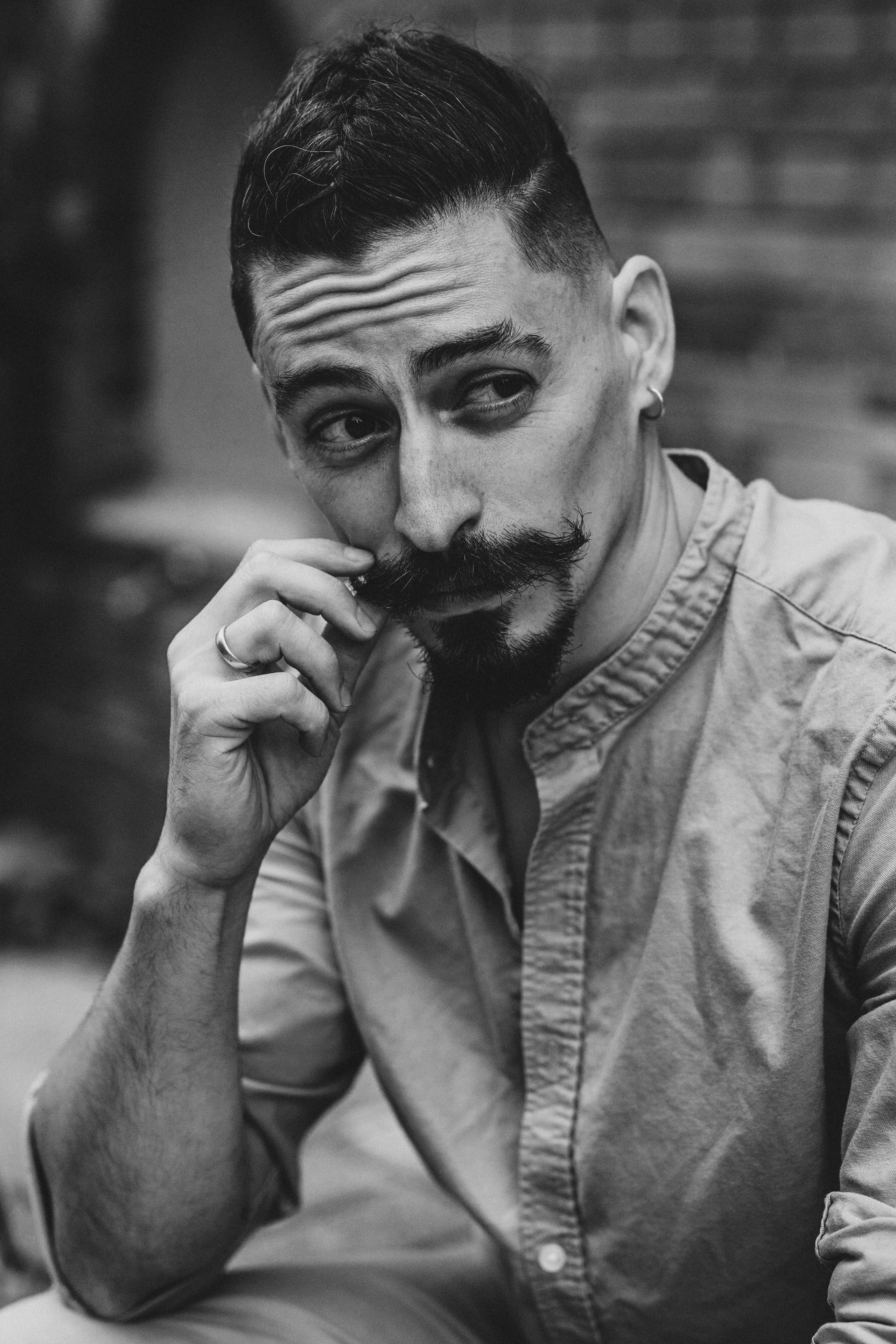 черно-белый портрет мужчины трогает себя за усы