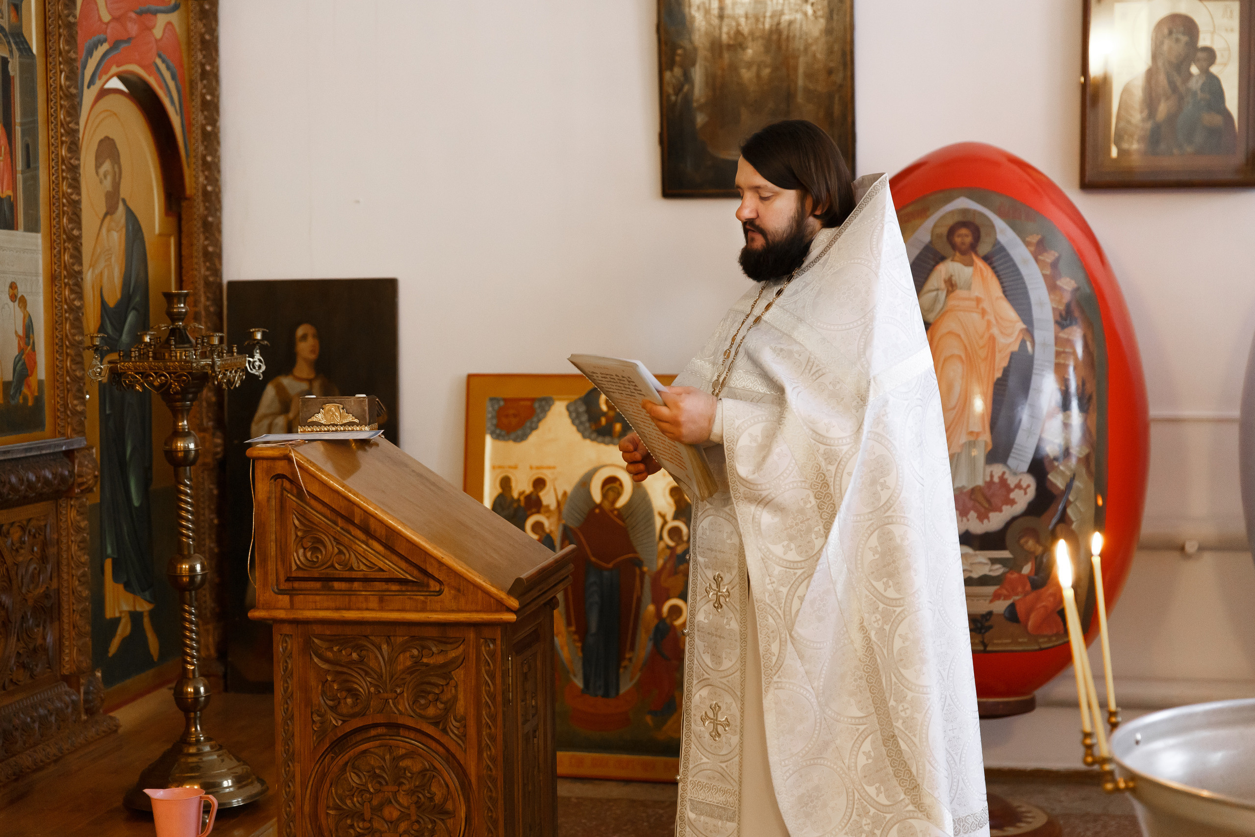 священник читает молитву на Крещении