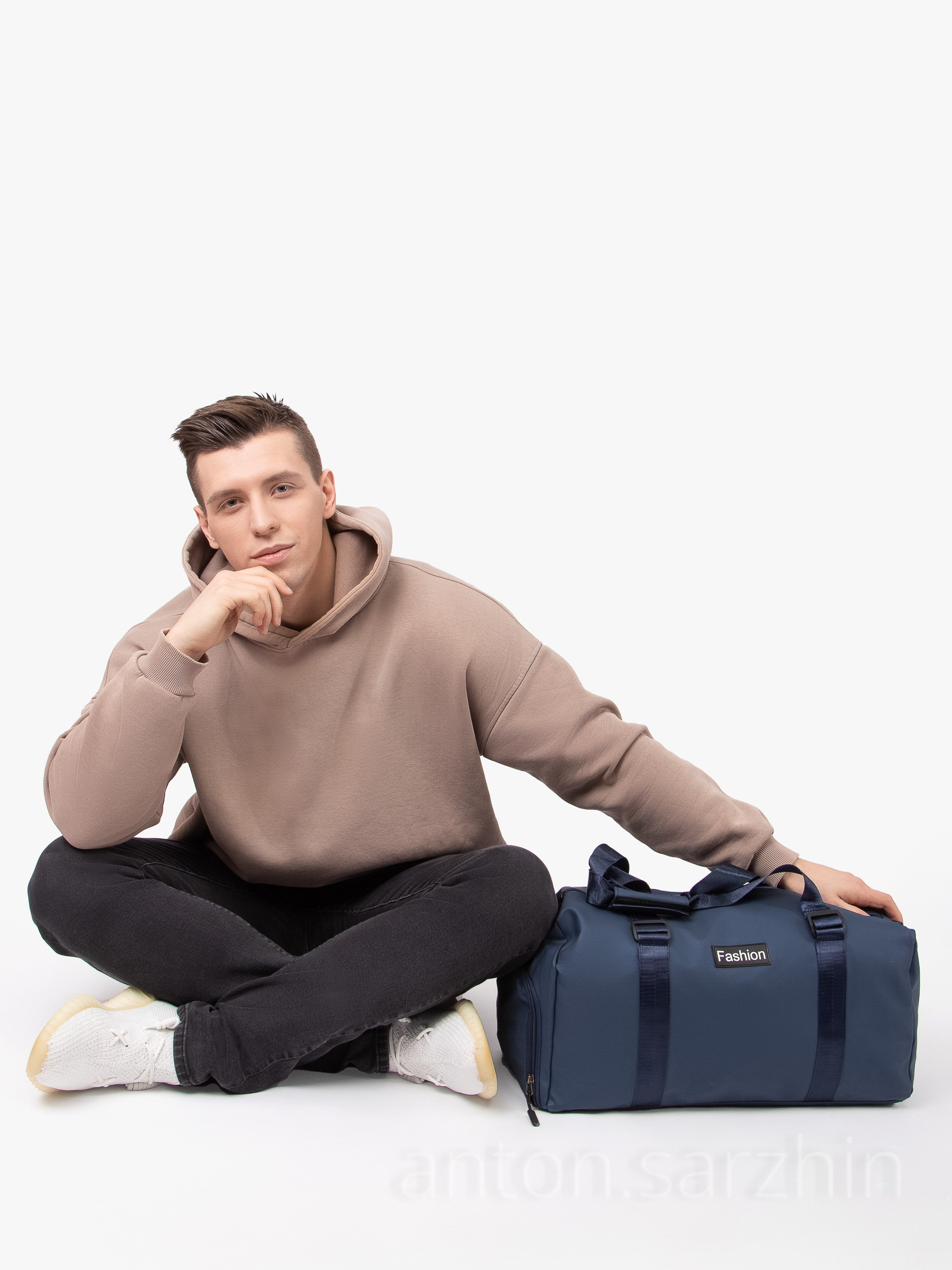 Съемка спортивной сумки рядом с мужчиной сидя