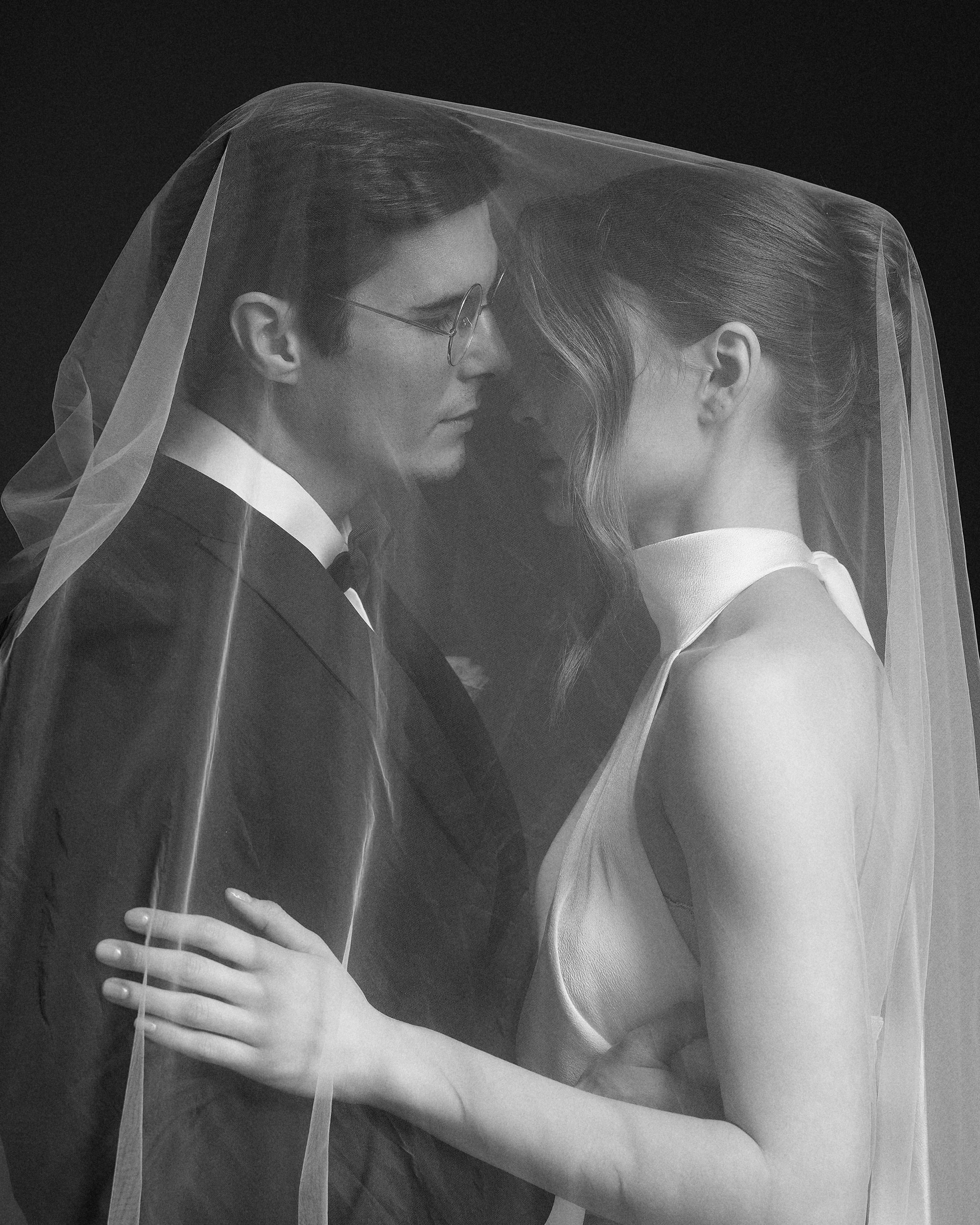 Фата создала их личное пространство. Никого вокруг, только он, она и полупрозрачная дымка. Очень интимный момент на тёмном фоне. Свадебная фотография, фотограф Дмитрий Цветков, СПб