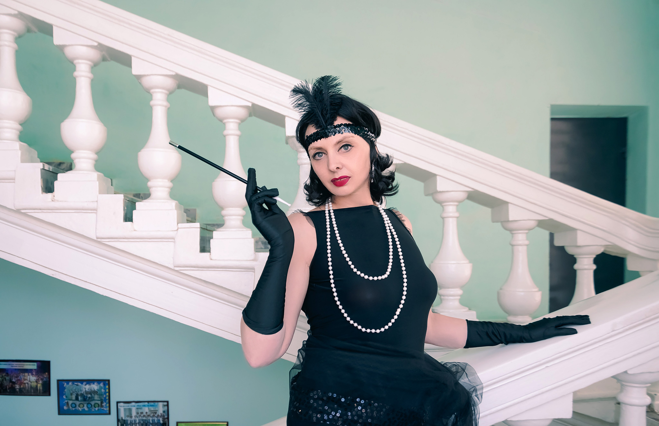 Девушка в стиле ретро, винтаж, Гэтсби на лестнице с сигарой.