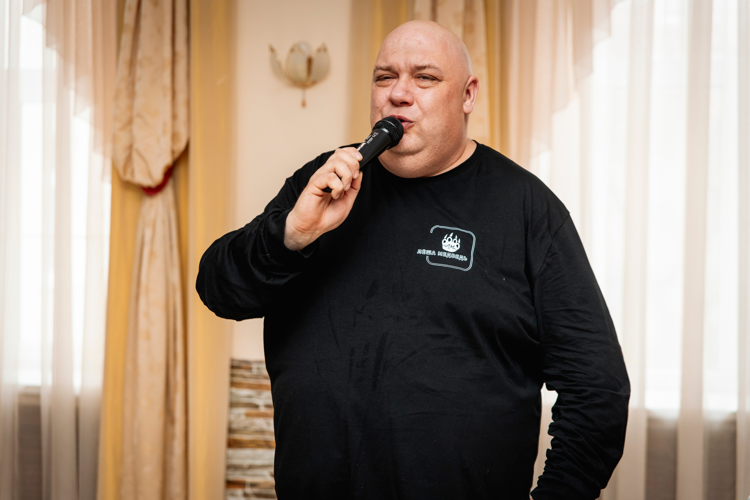 Лёша Медведь исполняет песню на благотворительном вечере.