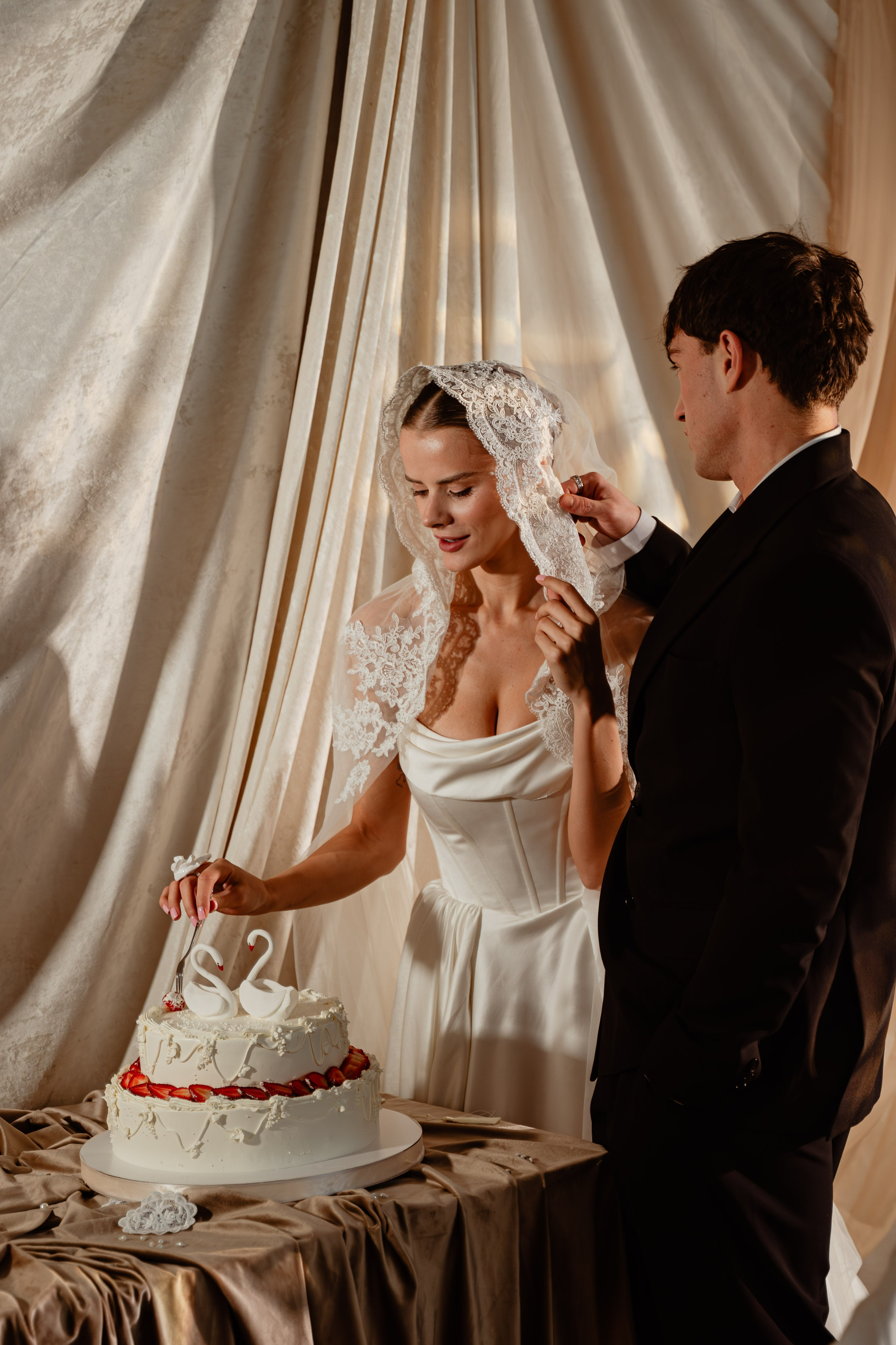 Жених и невеста у торта в мягком свете — атмосферная съёмка в стиле минимализм