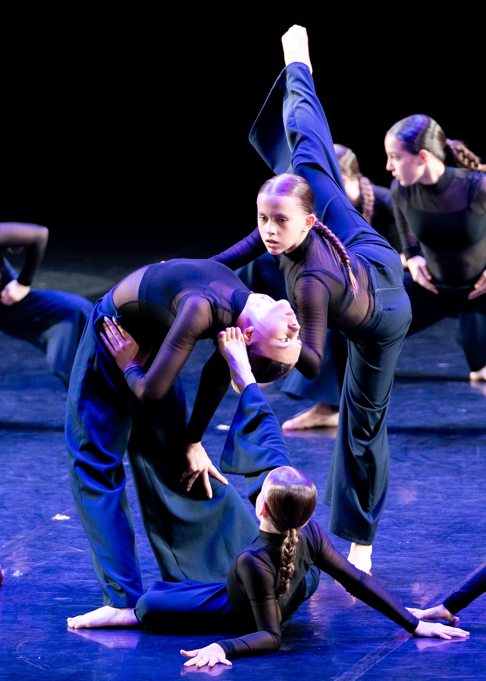 Академия танца Б. Эйфмана. Современный танец: группа танцоров в синих костюмах выполняет сложную акробатическую поддержку на сцене. Профессиональная фотография танцевального коллектива. Автор: Евгений Мальцев (evrednix.ru).