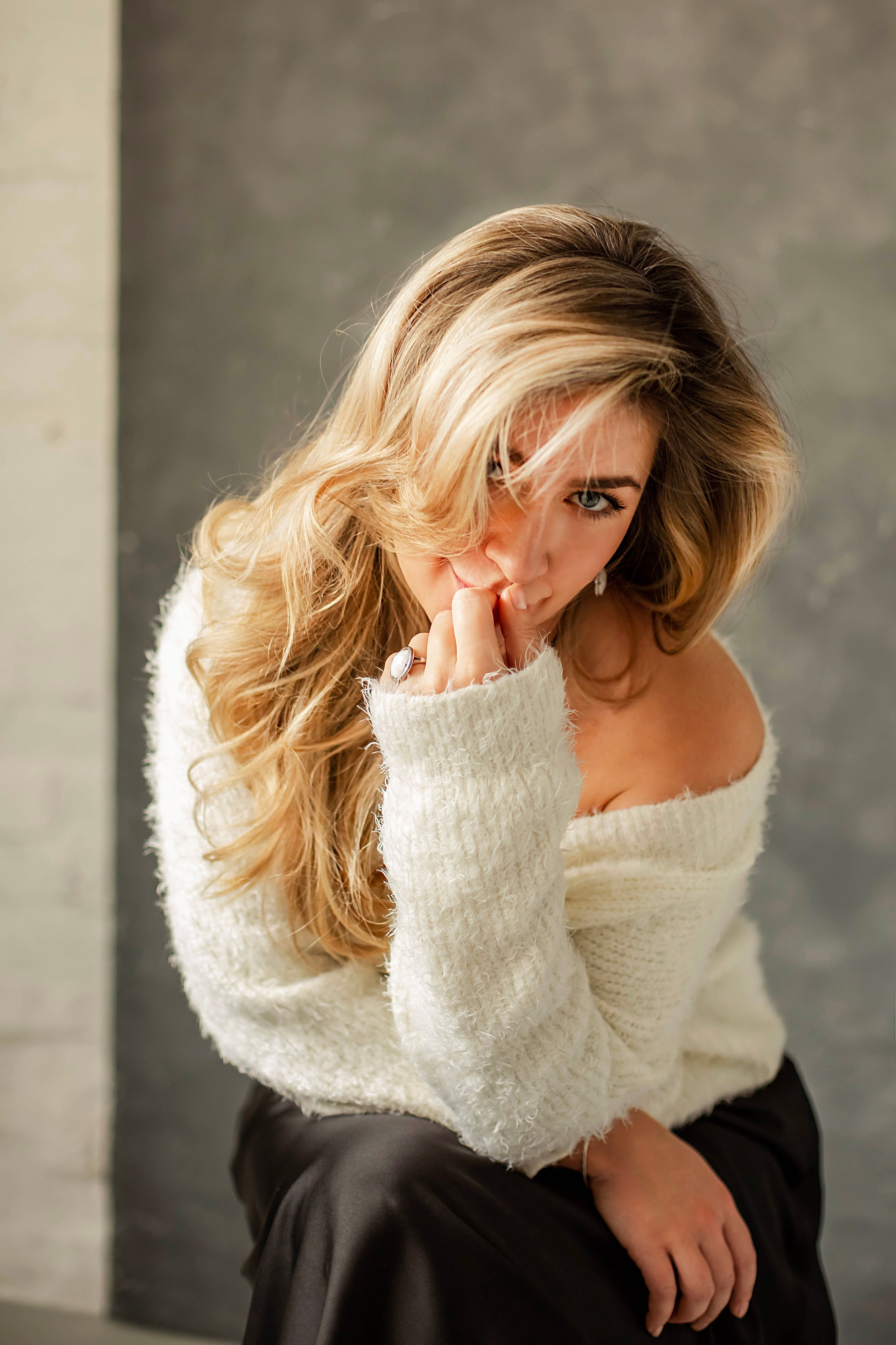 Портретная съемка девушки с игривым взглядом и обнаженным плечом на фоне венецианской штукатурки