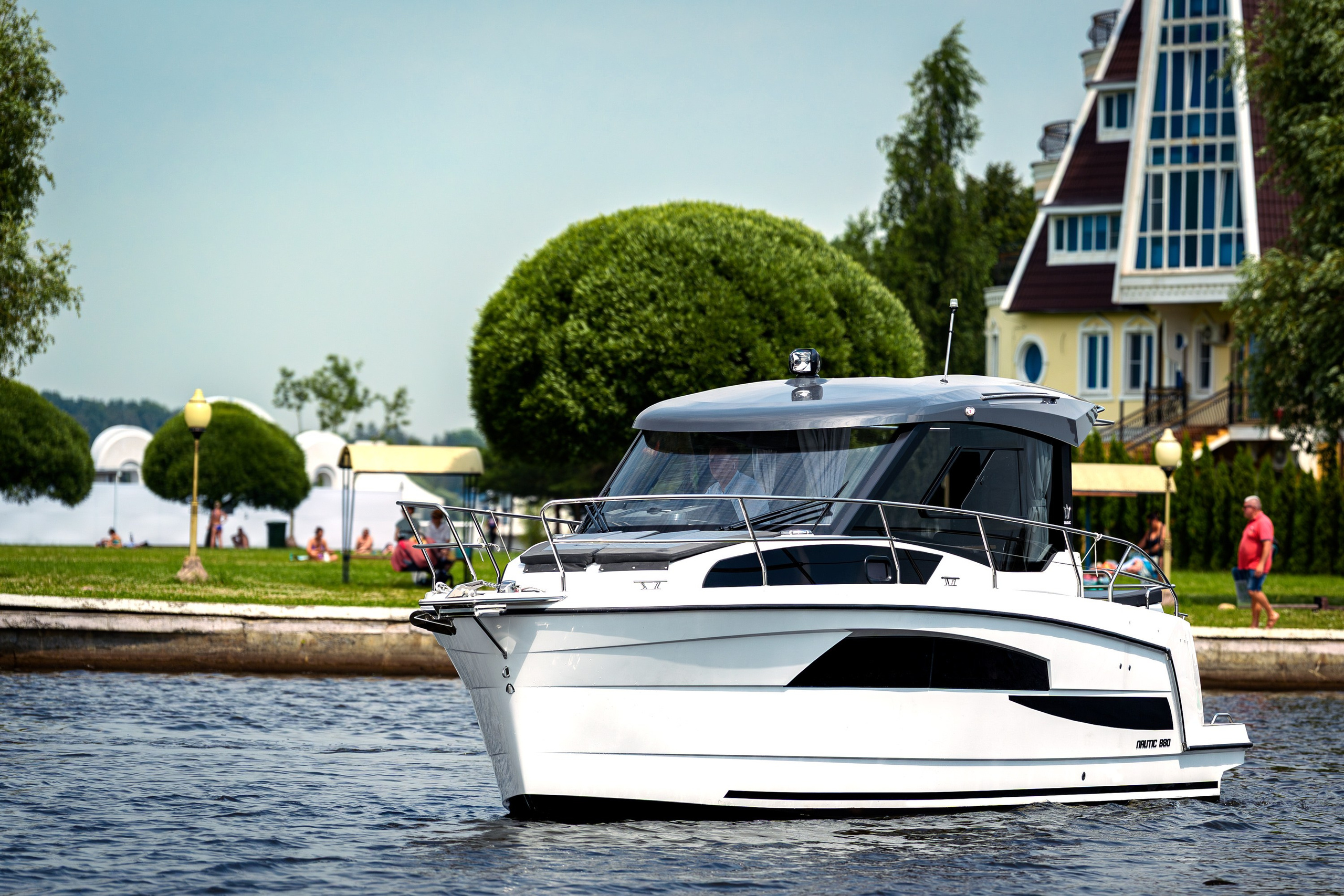 Nautic 880 движется по воде на фоне зелёного берега