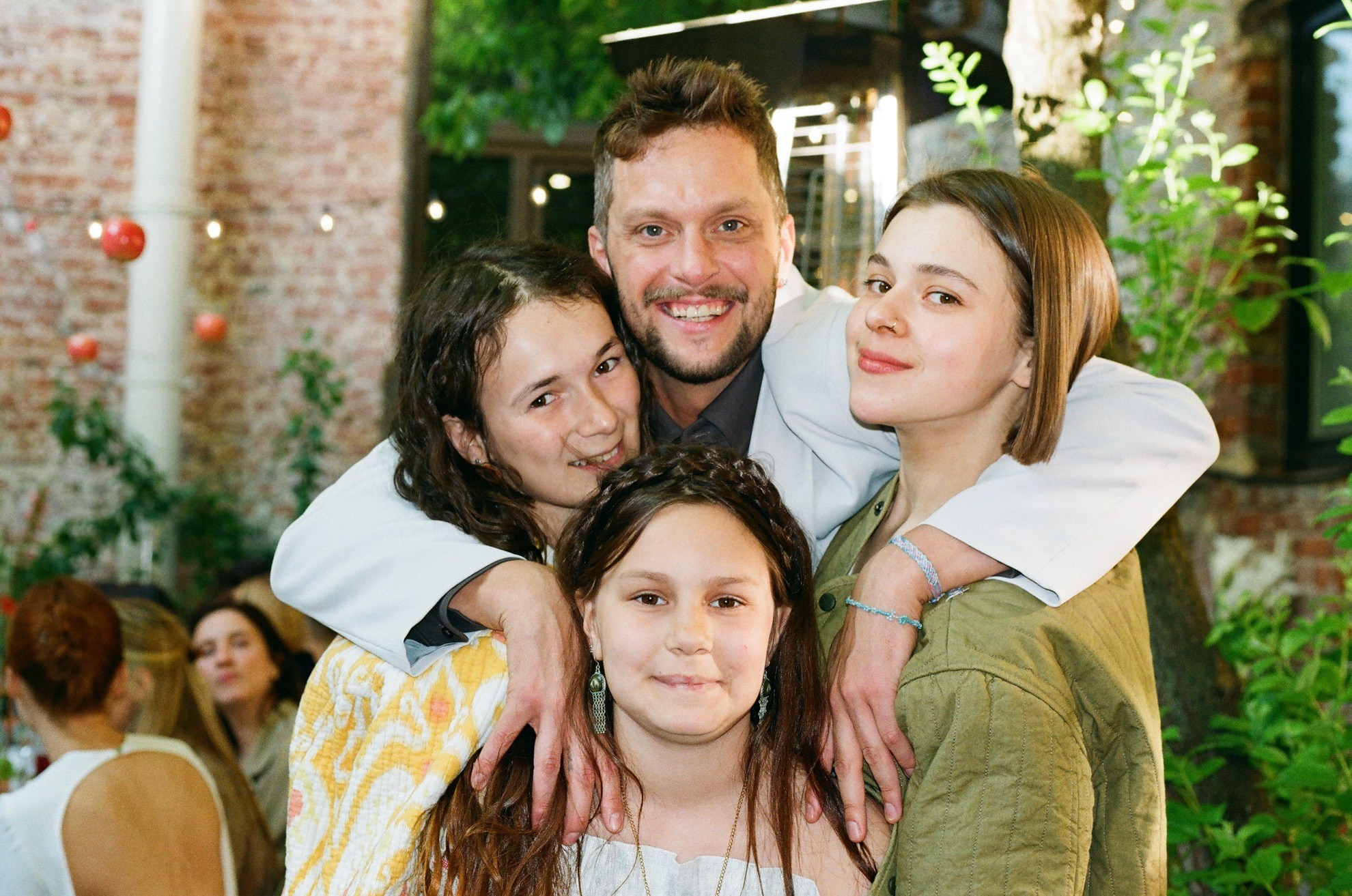 Плёночный кадр: гости свадьбы позируют в саду, живые и тёплые эмоции