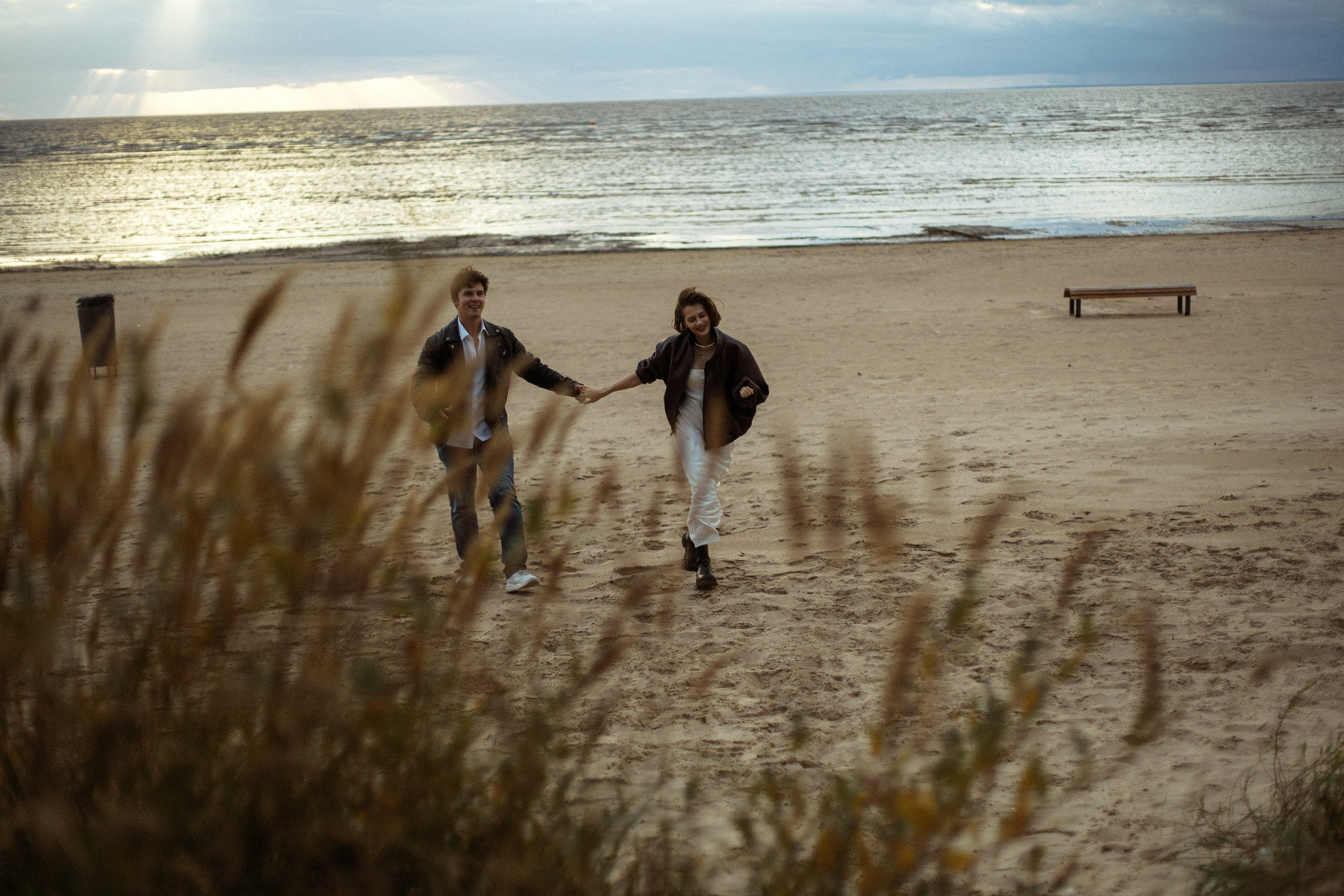 Девушка и парень держатся за руки — тёплая Love Story на берегу Финского залива