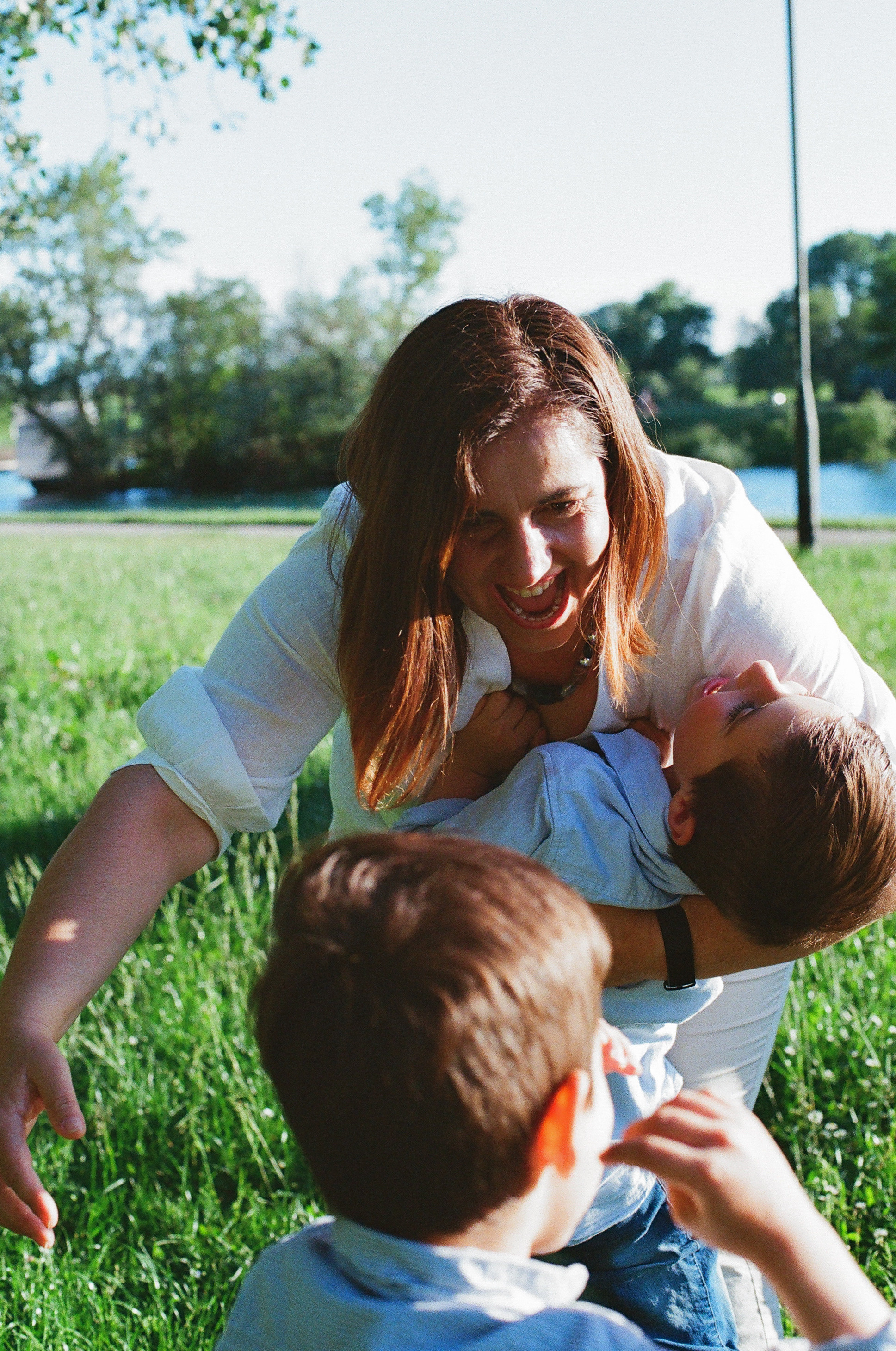 a mother is playing catch with her sons