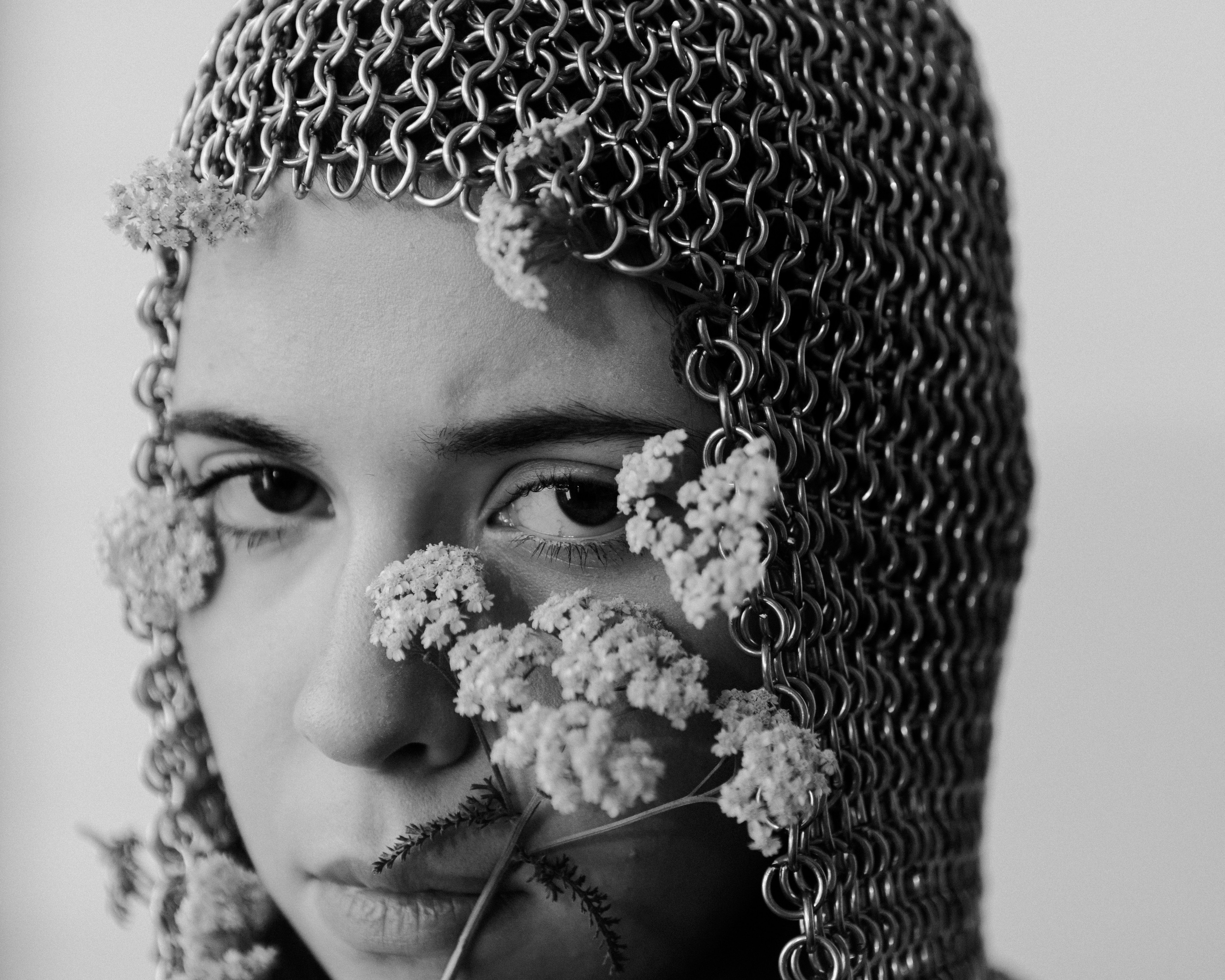 Студийный портрет девушки с цветами и кольчугой