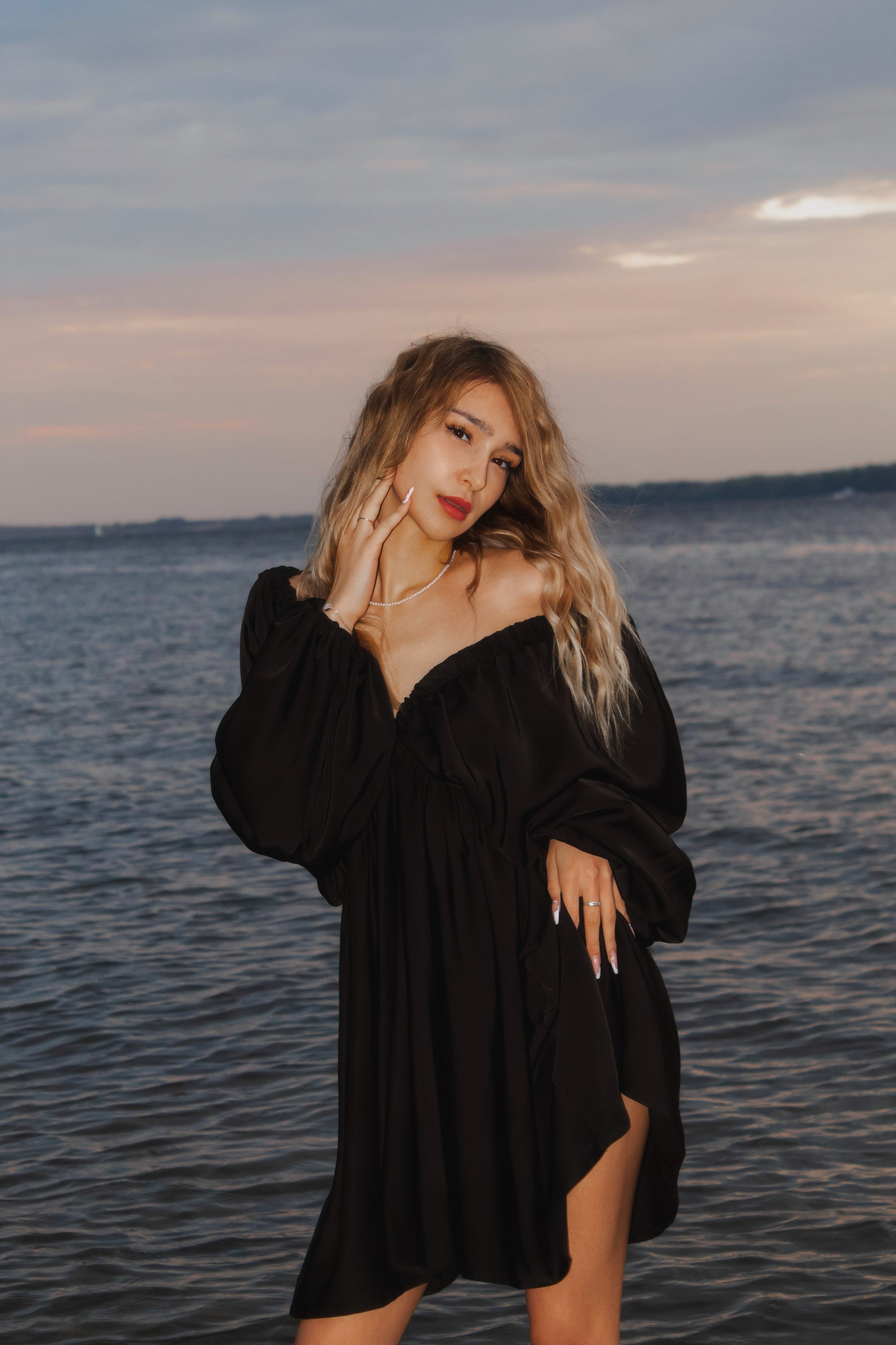 портрет загорелой девушки в платье на фоне моря вечером