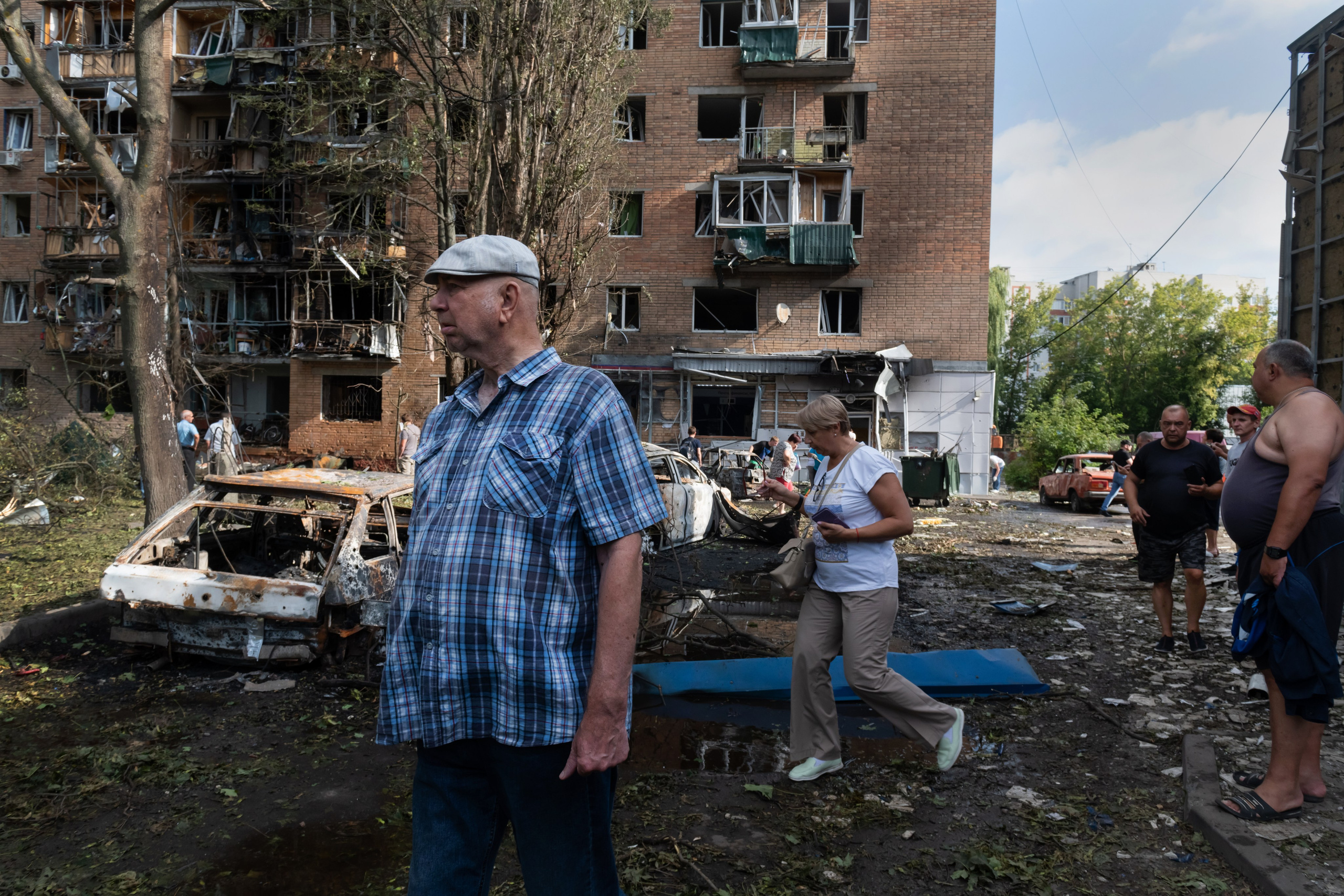 People walk near an apartment building damaged after shelling by the Ukrainian side, in Kursk, Russia, Sunday, Aug. 11, 2024. (AP Photo)
