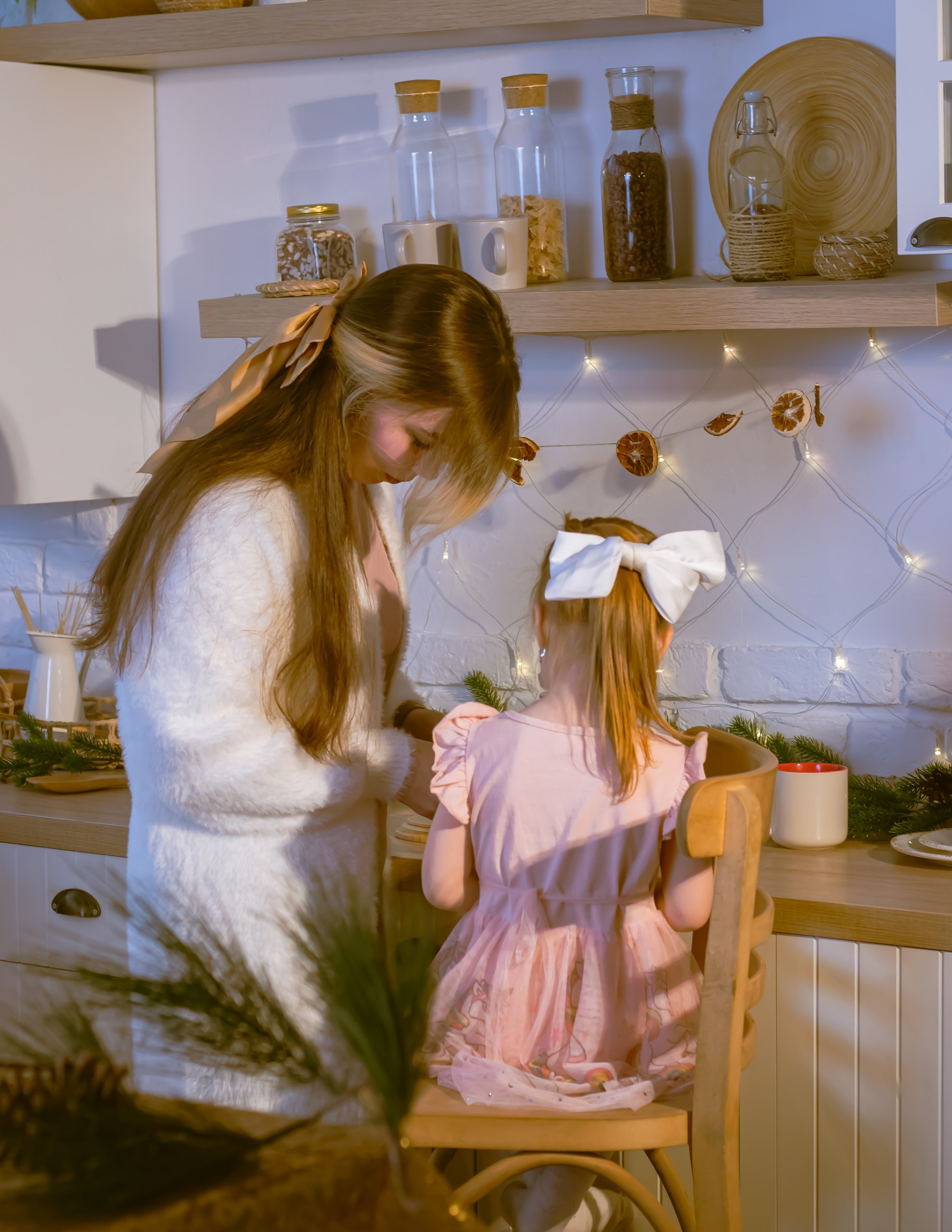 Маленькая девочка с мамой возле ёлки на кухне в новогоднем декоре, тёплая семейная съёмка, фотограф Карасёва Елена
