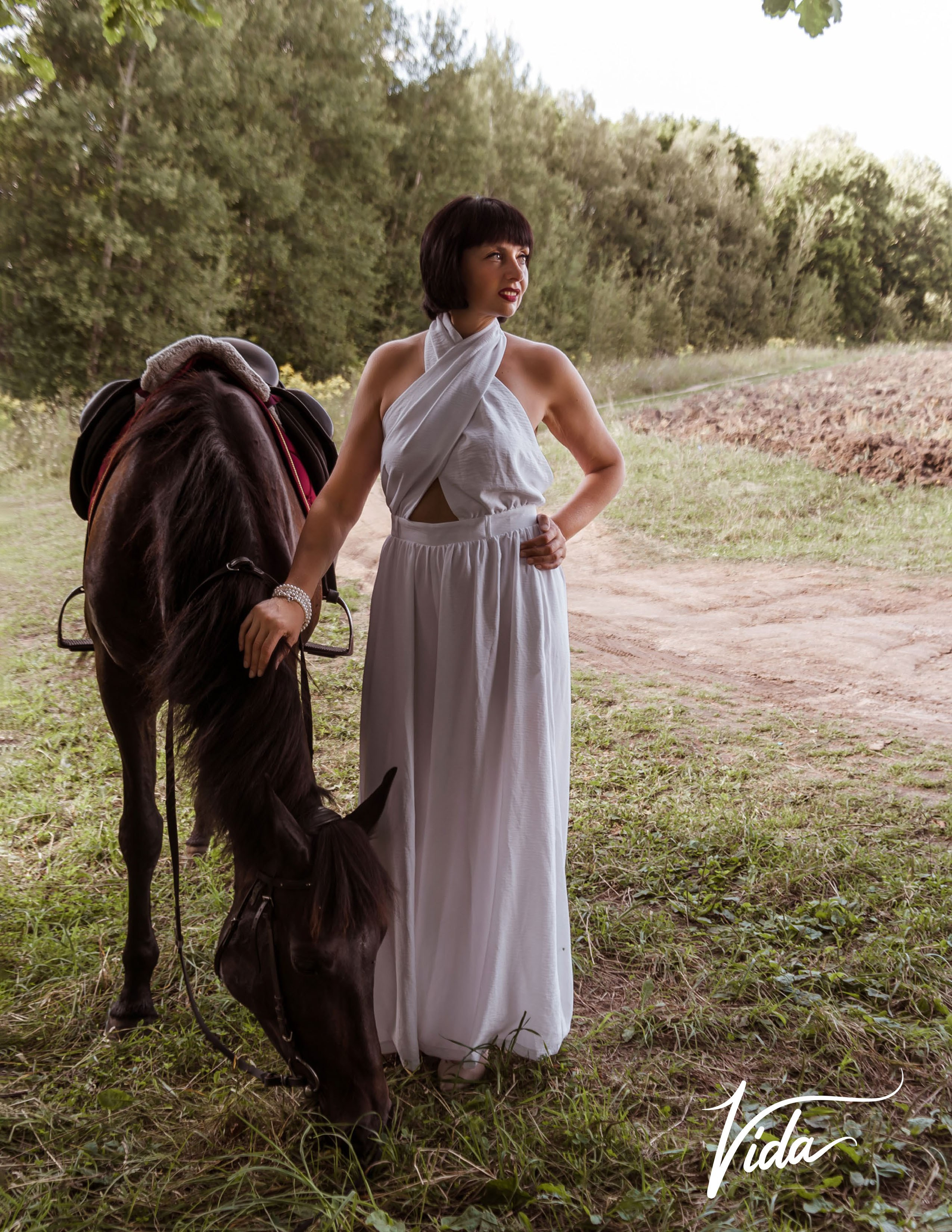 На фото отрывной лист журнала и девушка в белом комбинезоне с лошадь на полянке.