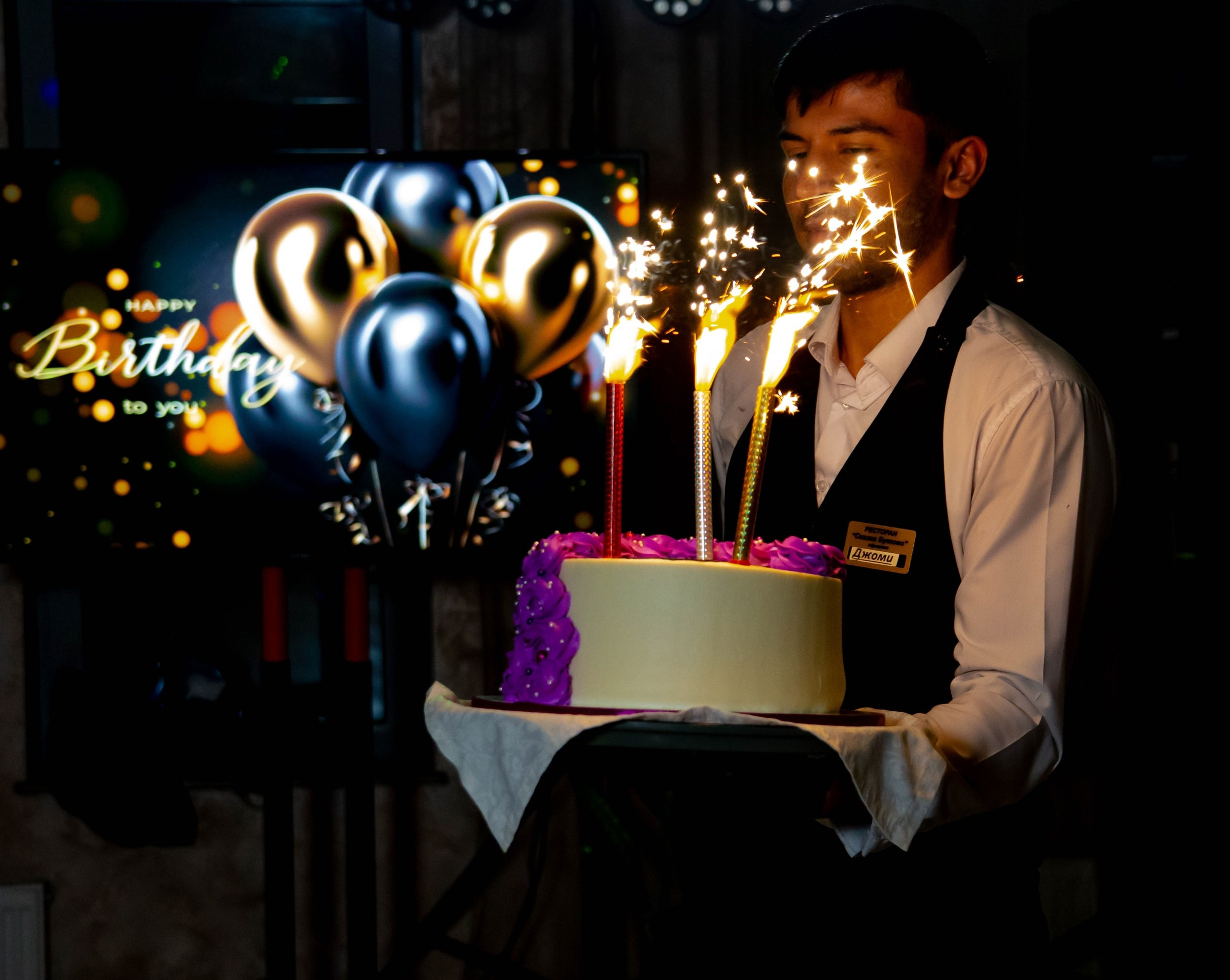 Официант вынес торт имениннику, зажгли свечи
