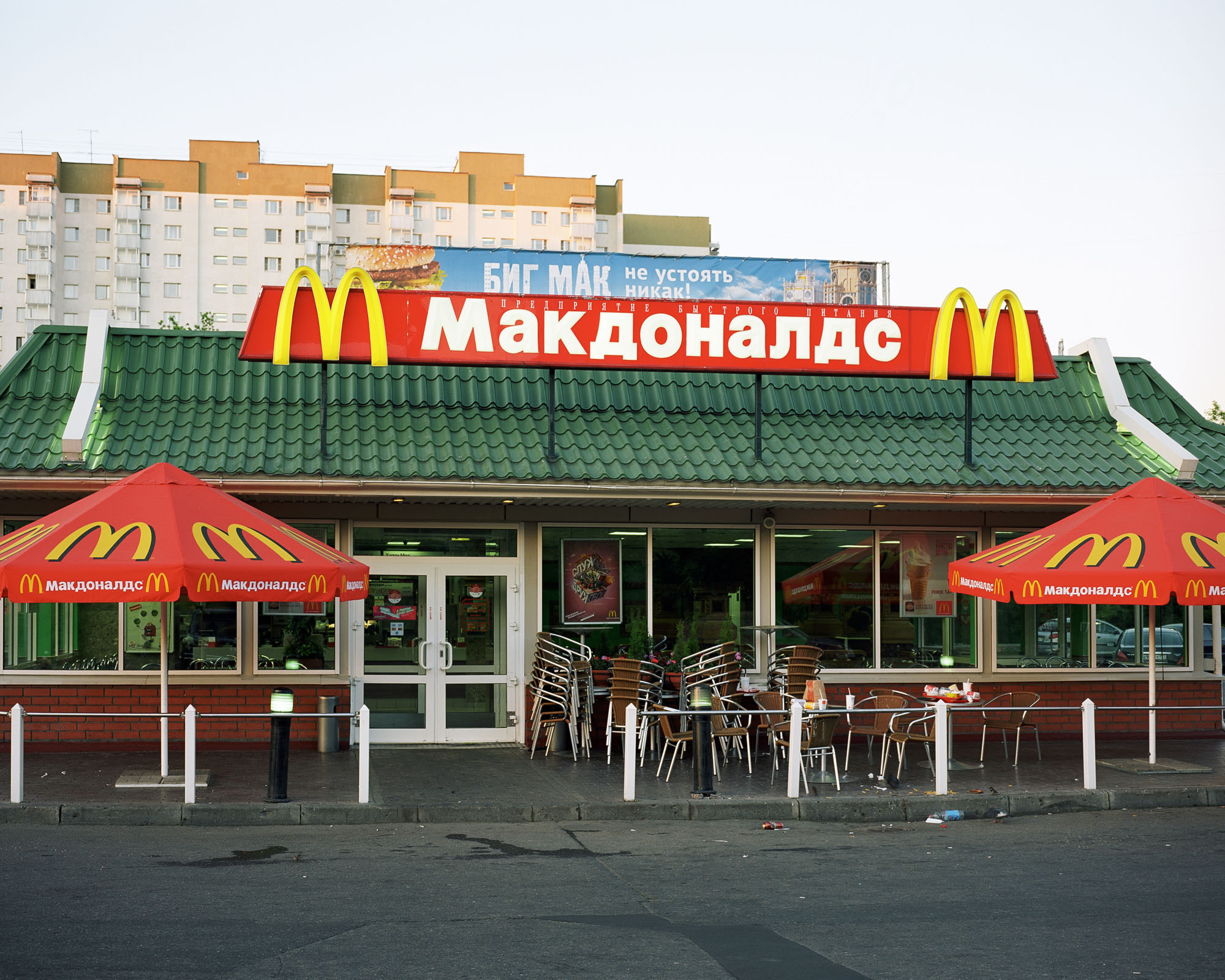 PLATE 61: Residential building, single storey café building c/w signs, posters and banners, parasols, outdoor furniture, waste bins, barriers