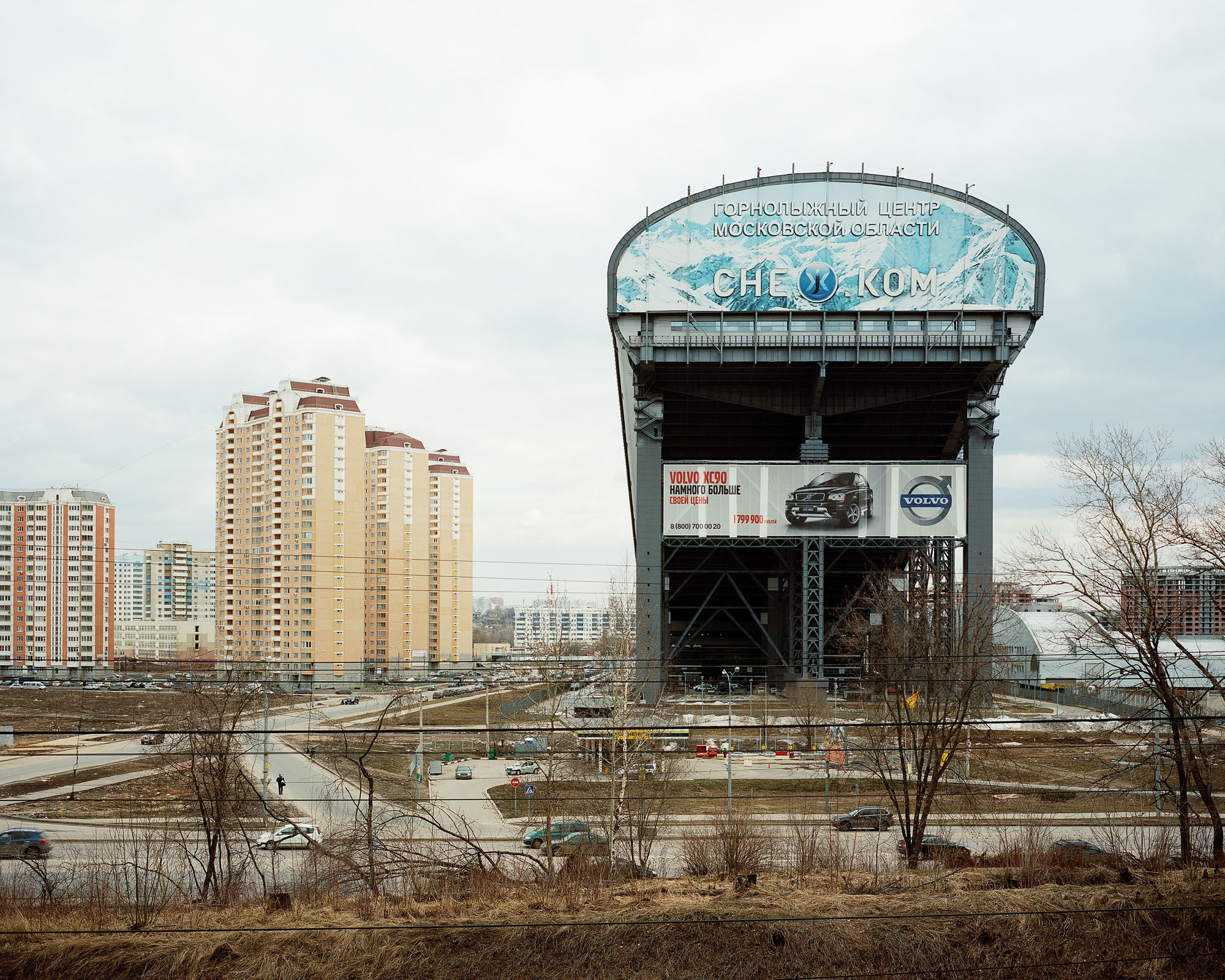 PLATE 35: Residential buildings, highway, trees (w/o foliage), indoor ski slope, banners (large), filling station, cars, figures of people, dry grass, lamp posts