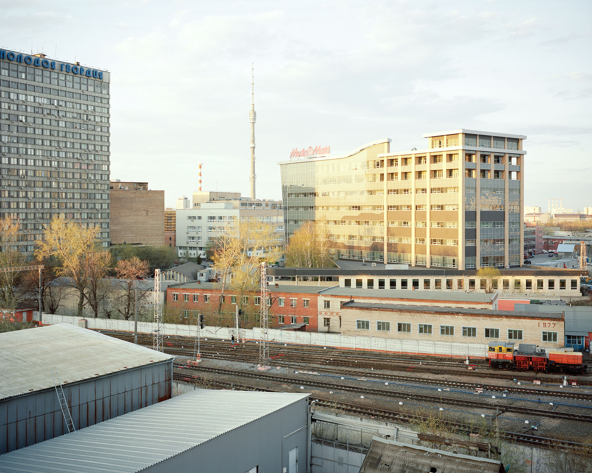 PLATE 15: Office buildings, assorted non-residential buildings, semi-permanent structures, railway tracks, television tower, work train, crushed rock, concrete modular fence (also includes ladder, A/C units, trees, chimney)
