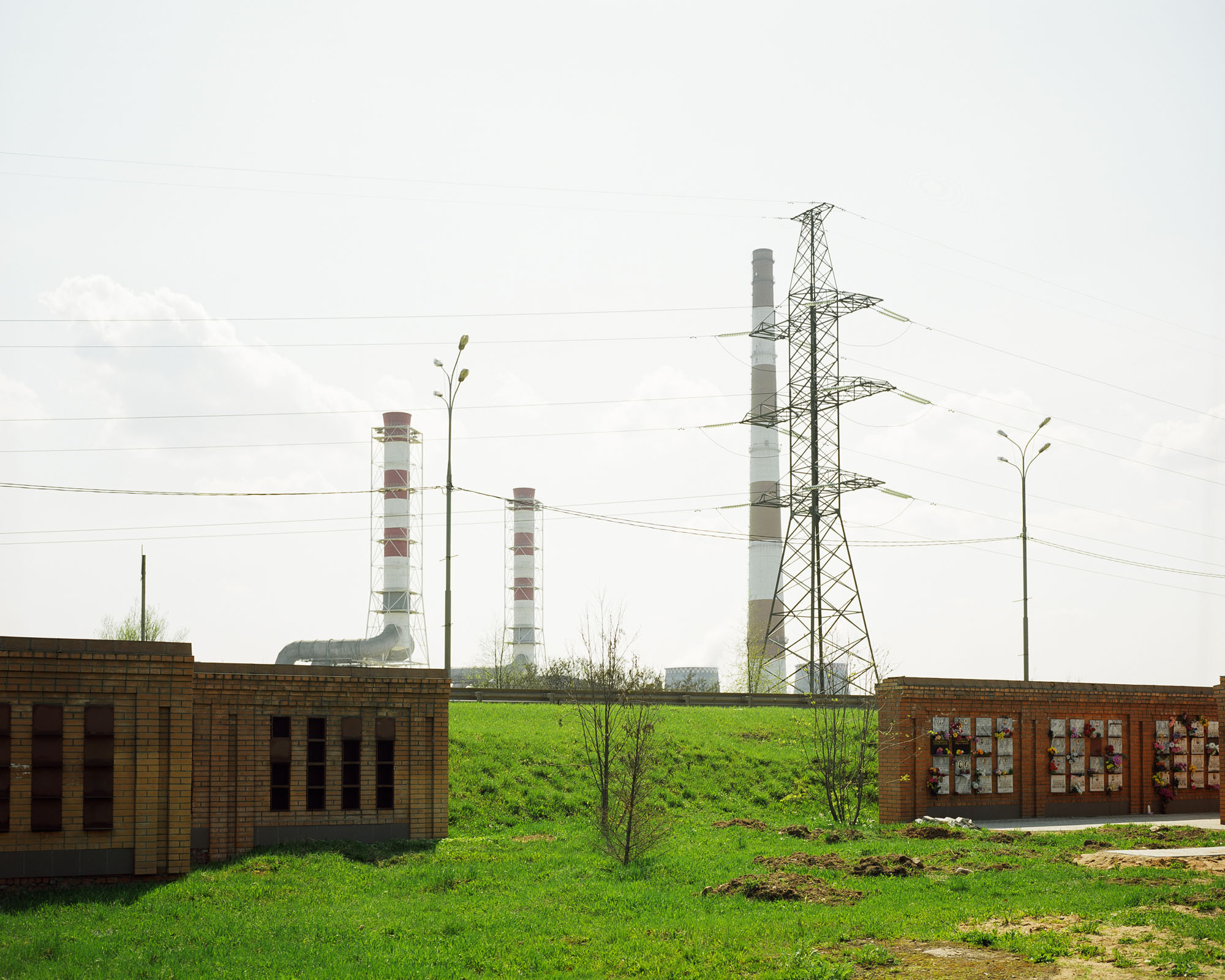 PLATE 18: High voltage tower, chimneys, highway barrier, trees, columbarium, lamp posts (also includes grass, patches of sand, power lines)