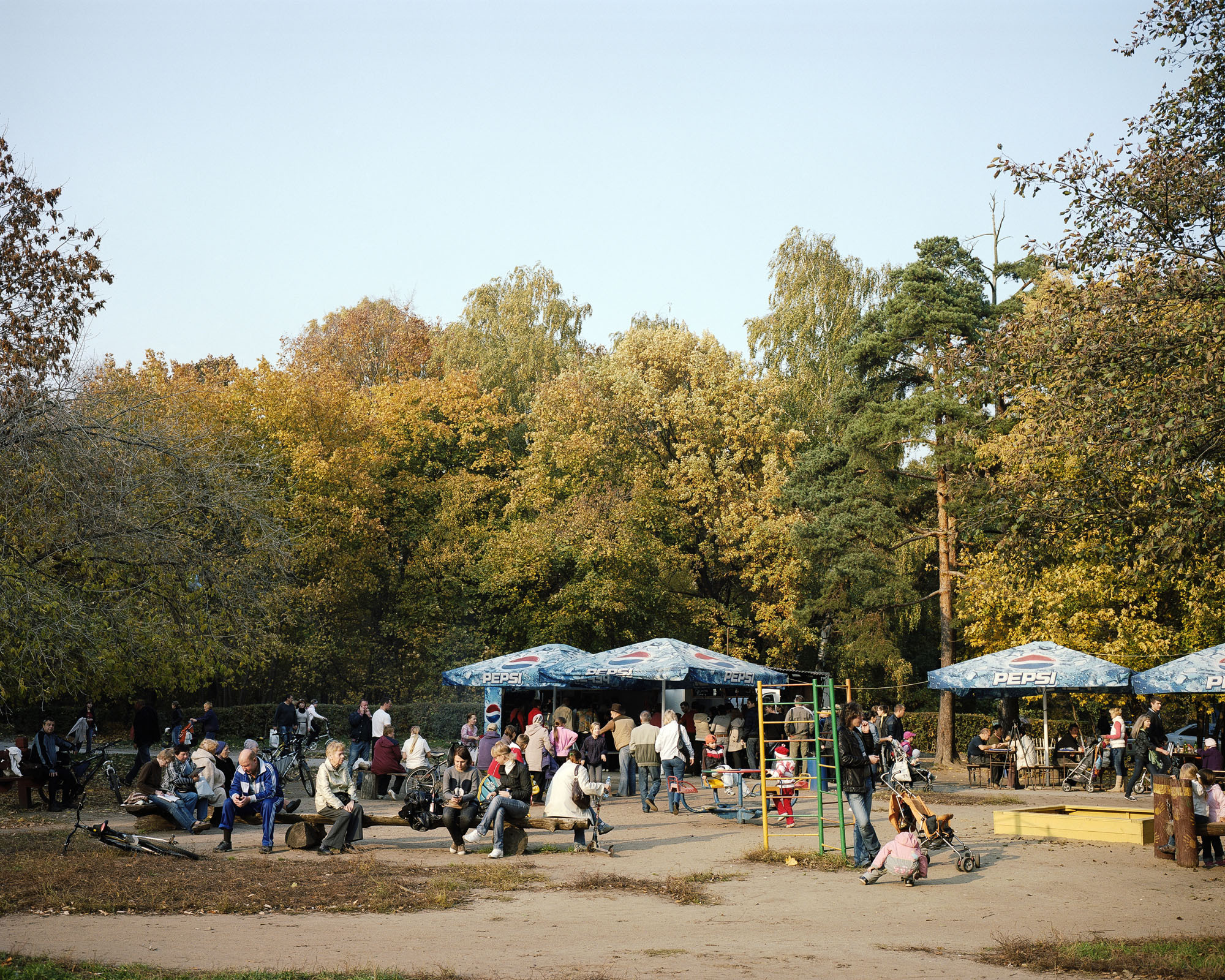 PLATE 45: Figures of people at leisure, parasols (with ‘Pepsi’ logo), recreational equipment, summer café, benches, other outdoor furniture, baby strollers, bicycles, trees
