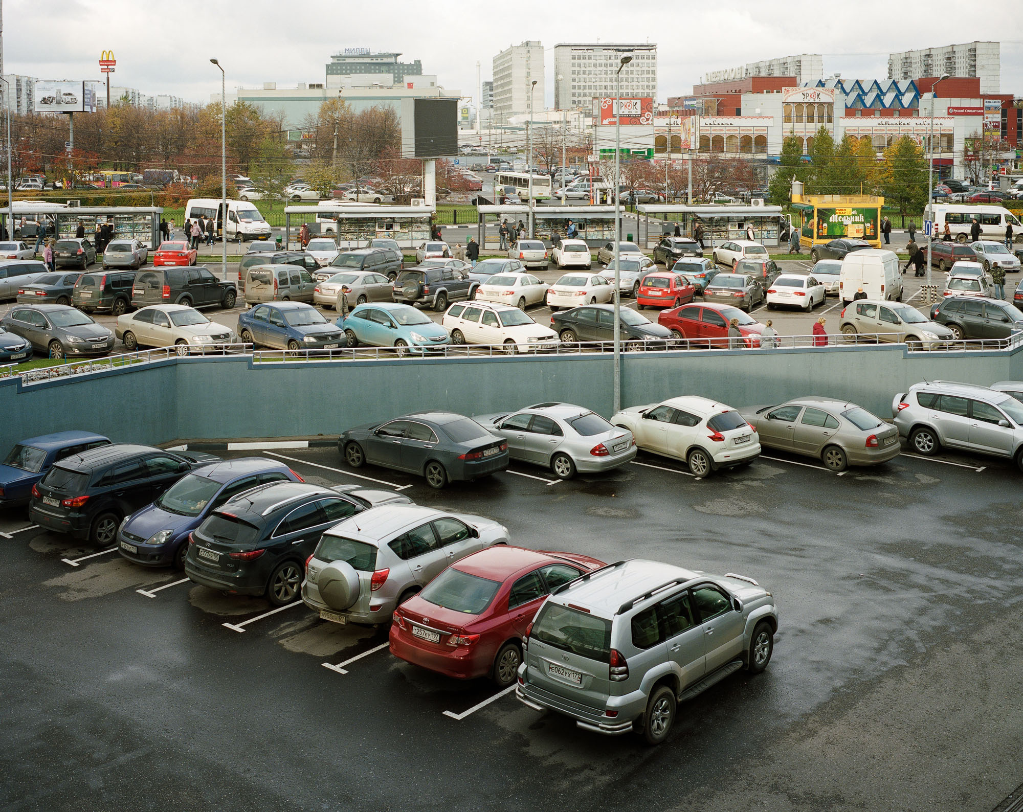 PLATE 51: Bus stops, commercial and residential buildings, parking space, lamp posts with power lines, billboards and signs (also includes cars, buses, kiosks, A/C units, barriers, figures of people)