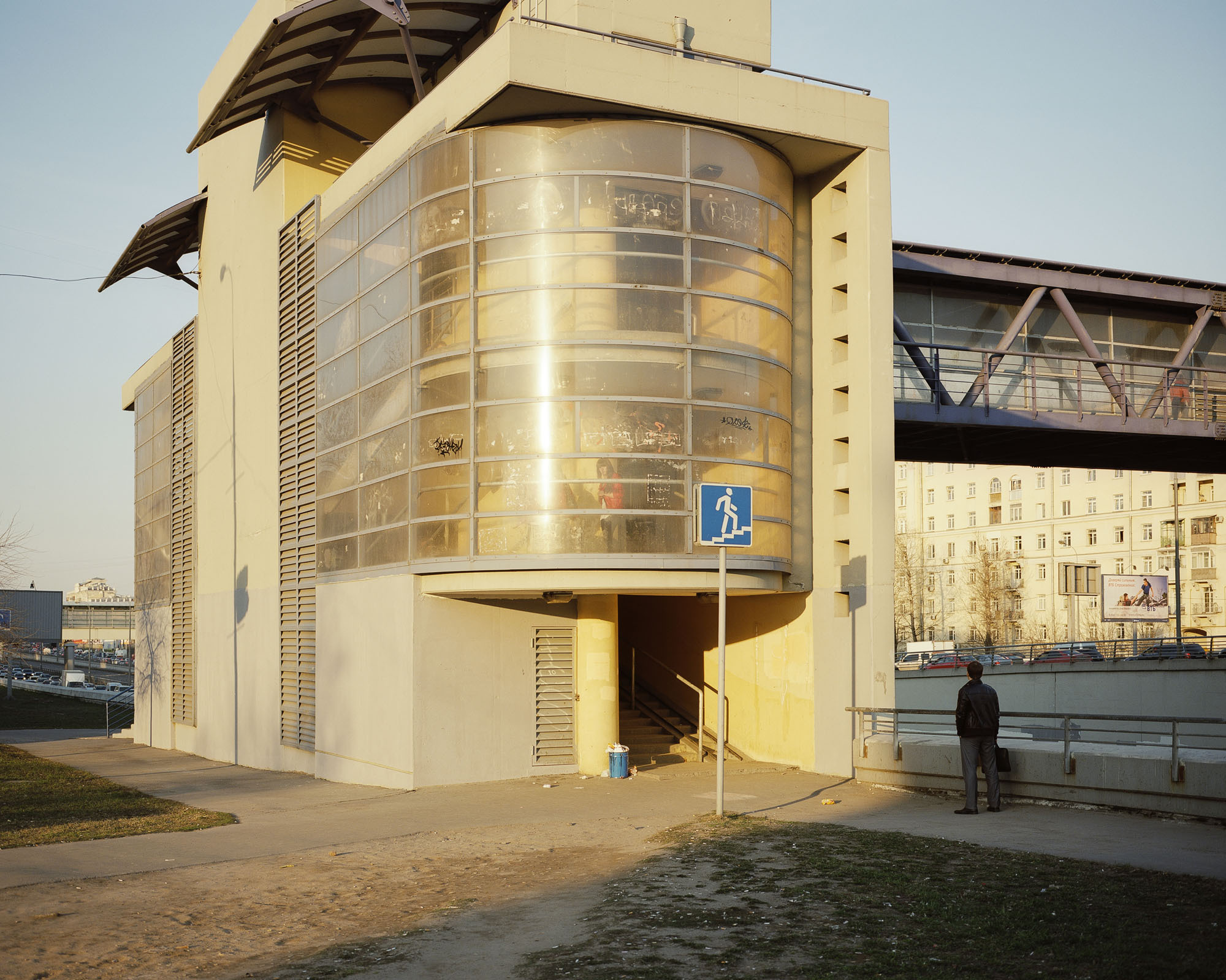PLATE 6: Pedestrian bridge, residential building, trees, cars, road sign, handrails, waste bin, billboards, figures of people