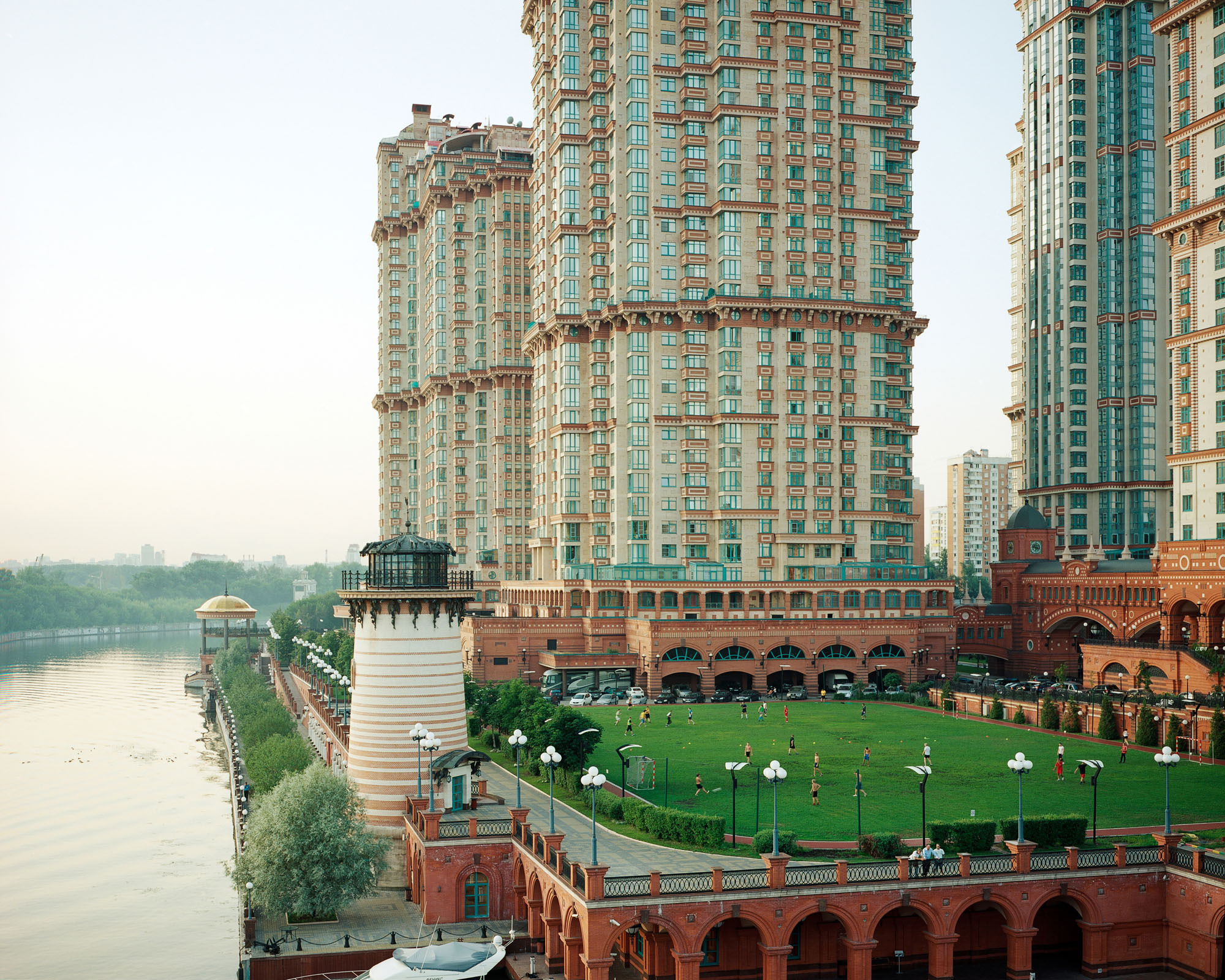 PLATE 11: Residential buildings, football field with figures of players, assorted lamp posts, assorted barriers and guardrails, waterfront with tower and gazebo, water reservoir, cars, trees