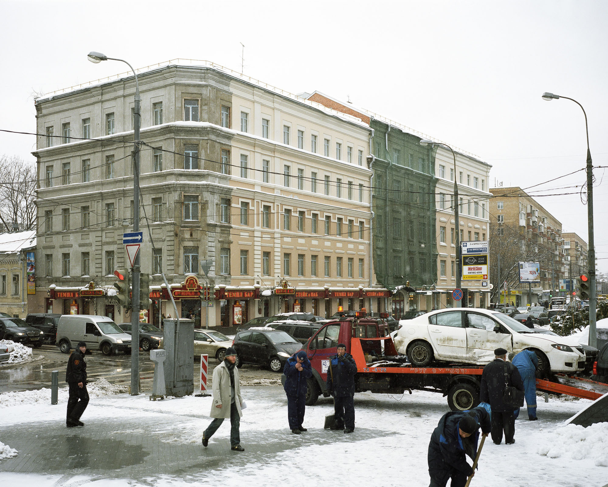 PLATE 47: Historical building under renovation (incl. construction net), residential buildings, lamp posts c/w power lines, snow, tow truck with car, assorted signs and billboards, traffic lights, road signs, assorted barriers, cars, figures of pedestrians and utility workers