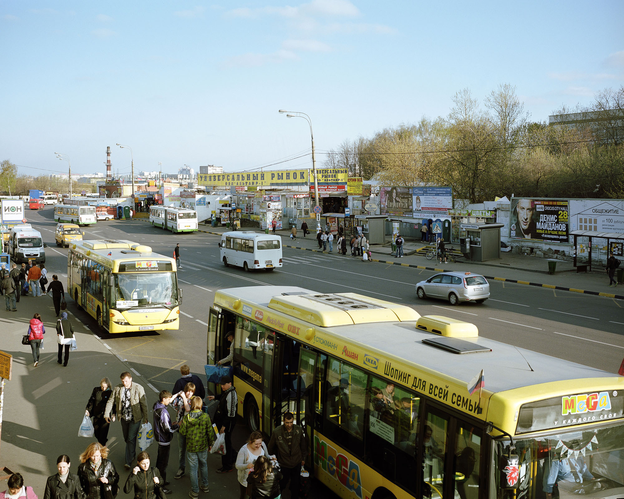 PLATE 2: Minibuses, buses (also in MEGA shopping mall livery), bus stops and kiosks, billboards, shop signs, banners, road signs, waste bins, lamp posts with power lines, taxi, trees, chimney, pedestrian crossing, figures of people