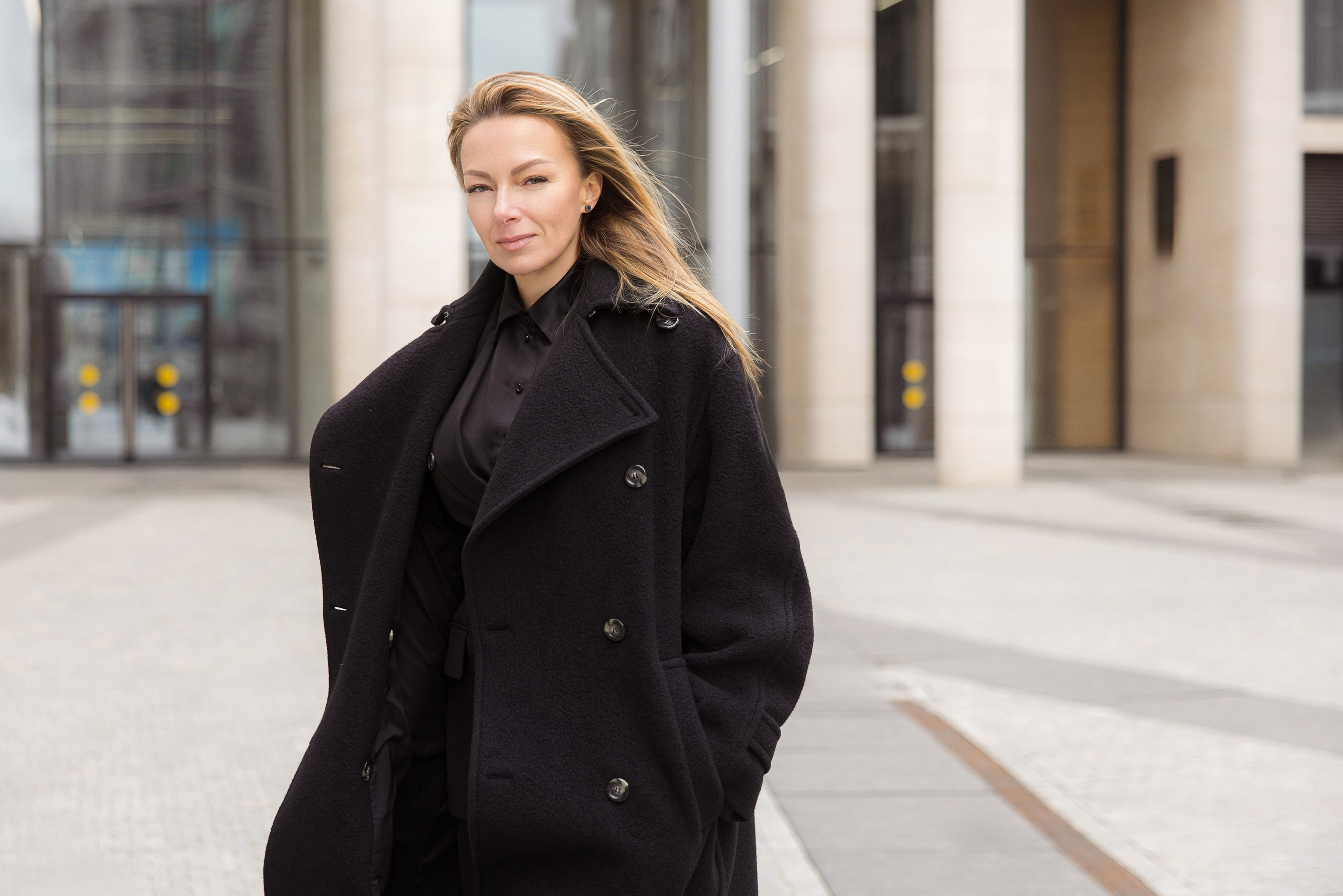 Бизнес-портрет девушки в черном пальто на улице