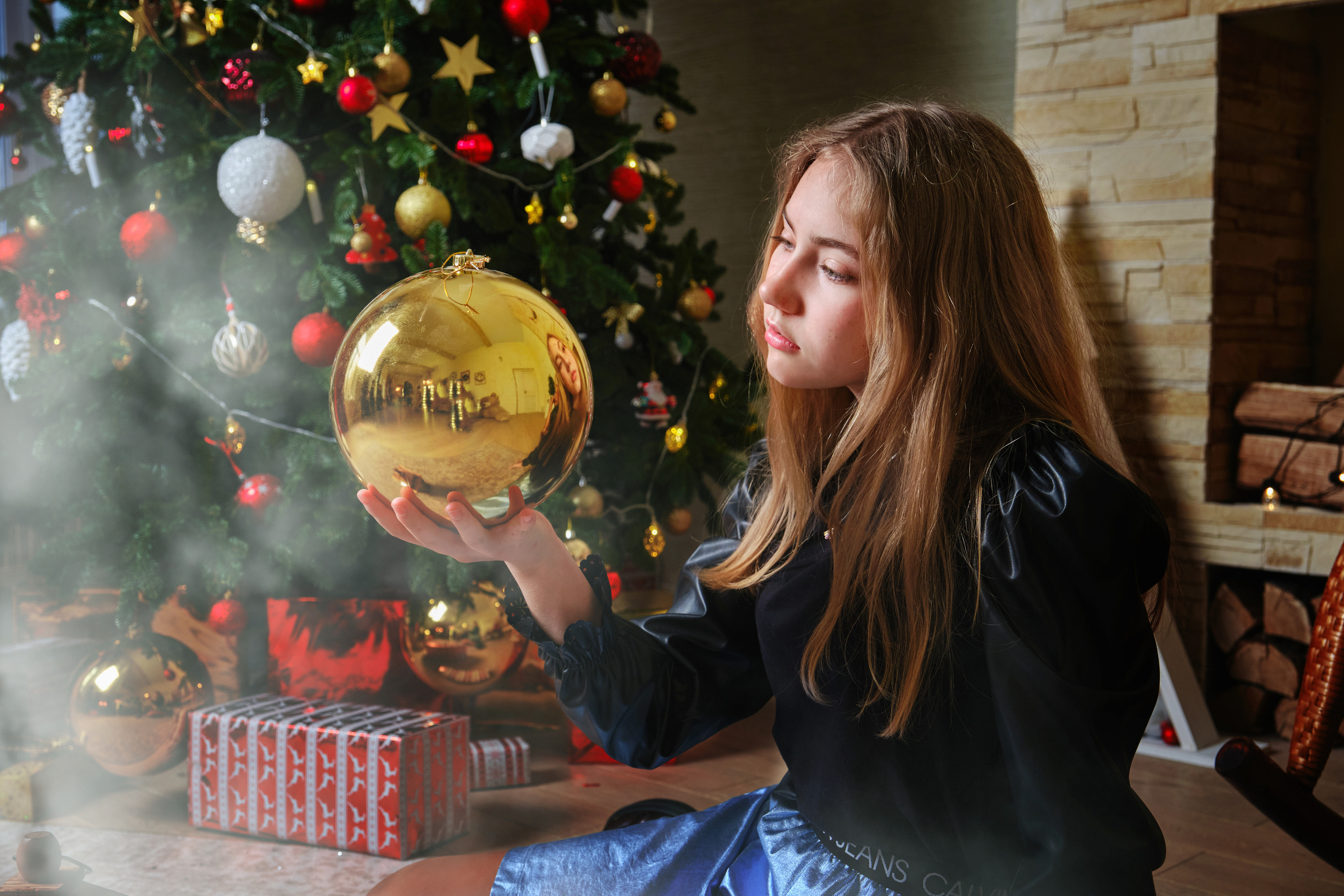 новогодняя фотосессия девушки в студии - портрет девушки с большим жёлтым шаром на фоне ёлки